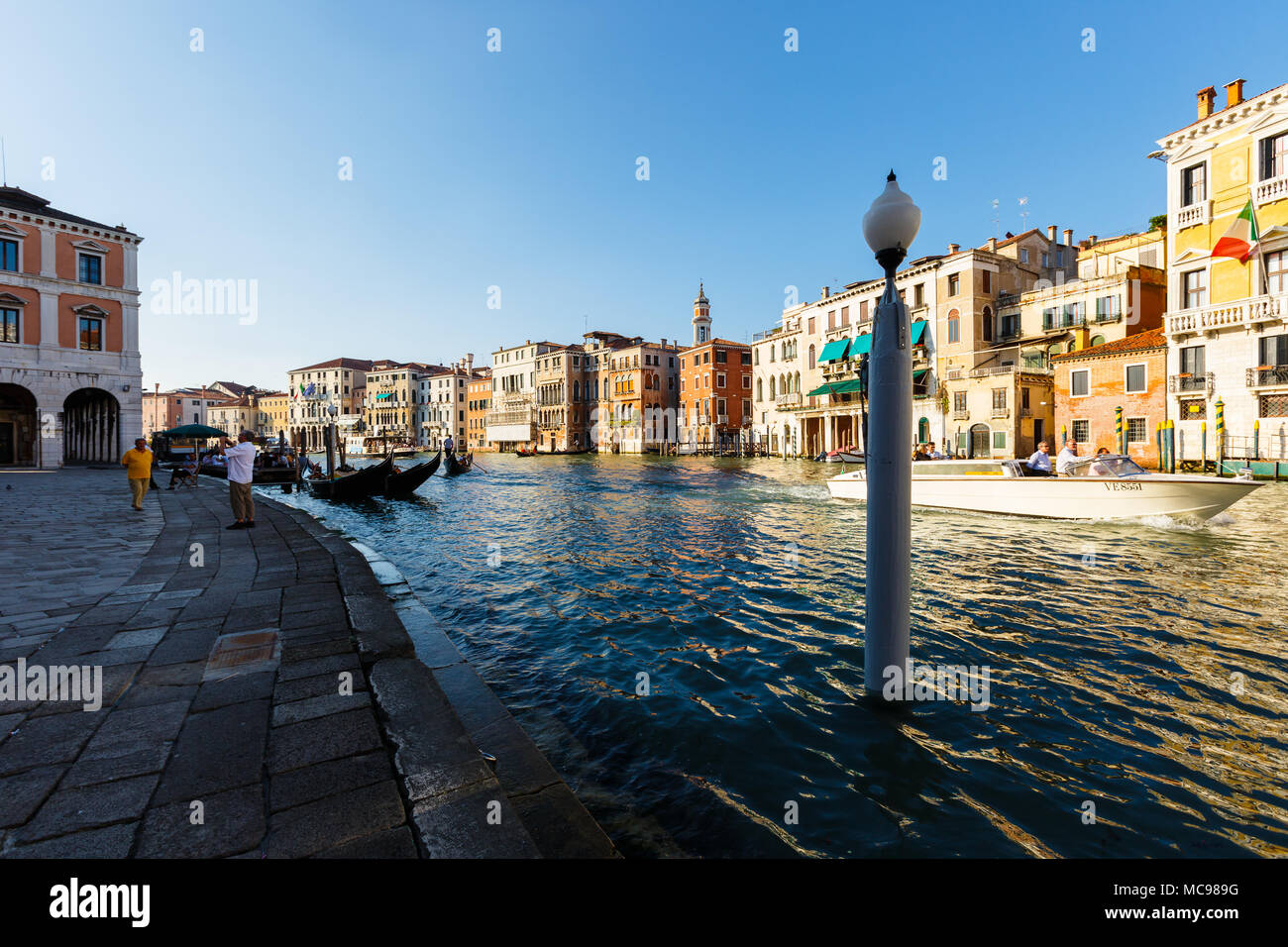 Venice, Italy - June, 21, 2013: Typical view to Venice city, to Grand canal, many tourists people enjoy a rest on gondolas and pleasure boat. Campanil Stock Photo