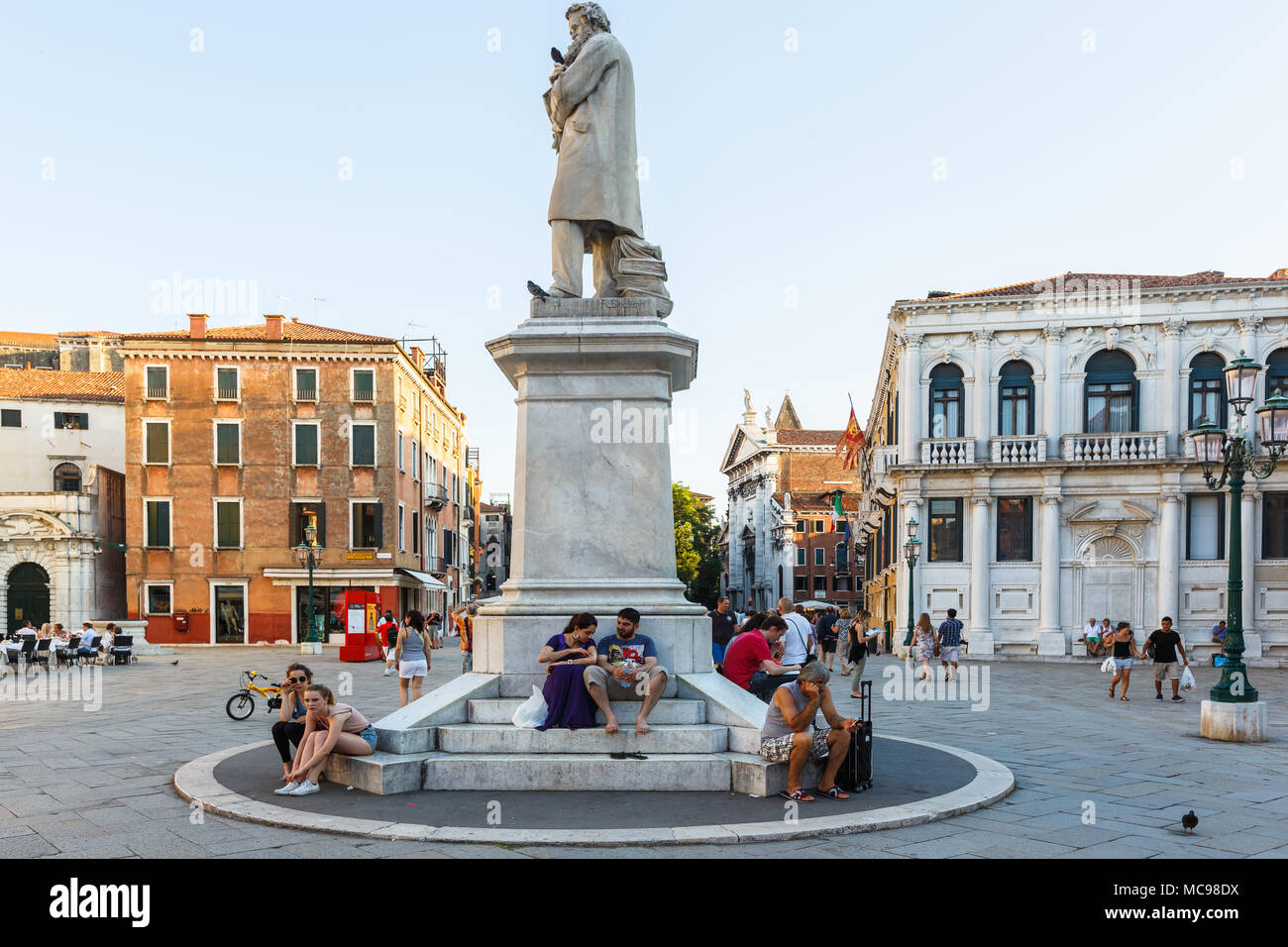 Venice, Italy - June, 21, 2013: evening on the San Stefano square. Many tourists sits near the Monument of Niccolo Tommaseo, Palazzo Loredan on the ba Stock Photo