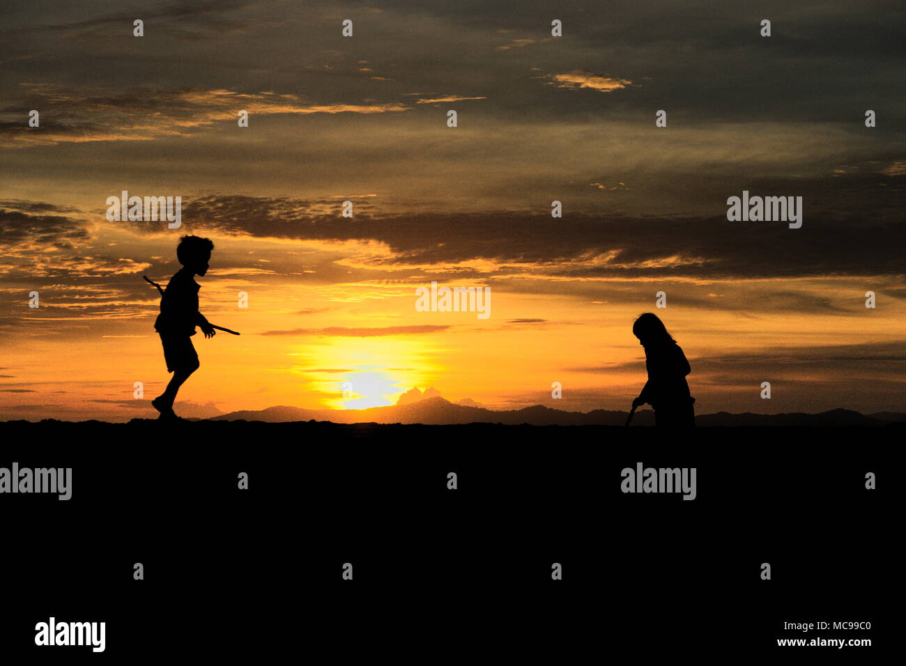Silhouette of Children Playing on the beach at Sunset Stock Photo - Alamy