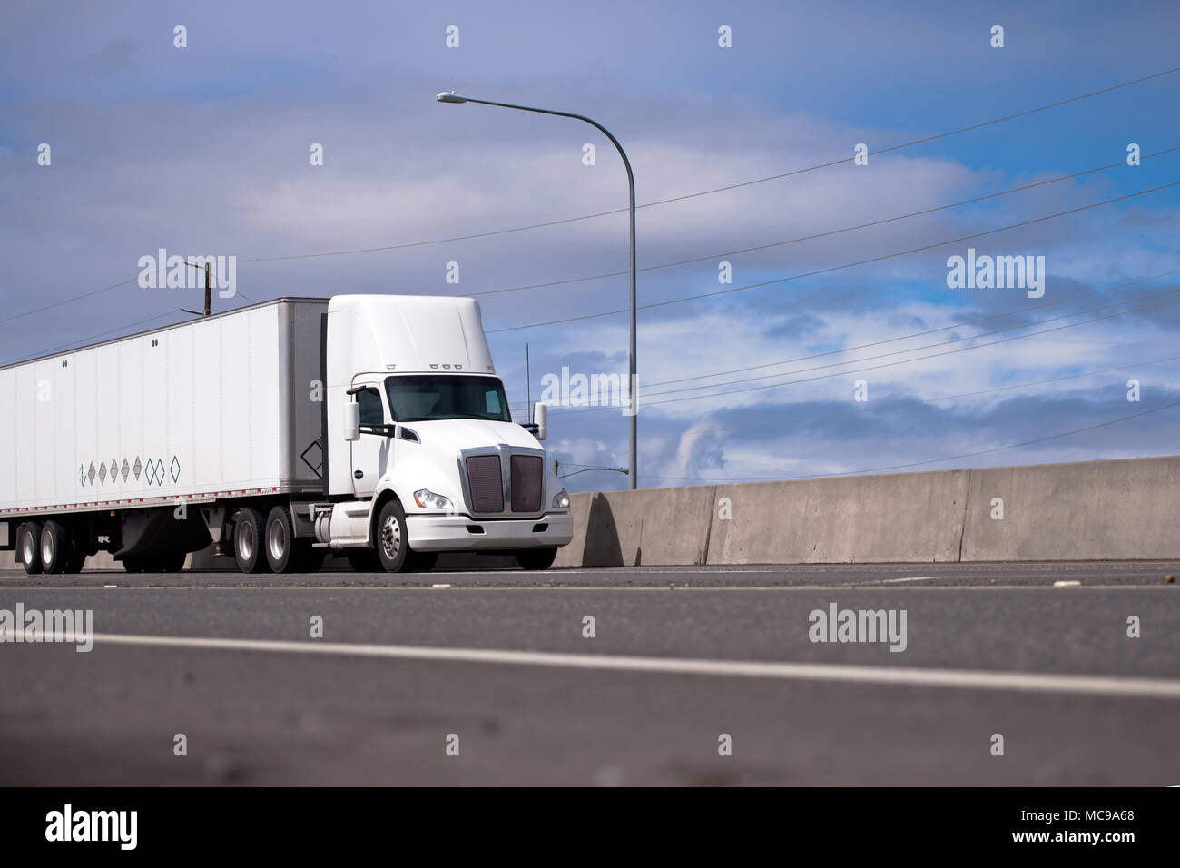 Powerful white day cab American made big rig semi truck with roof