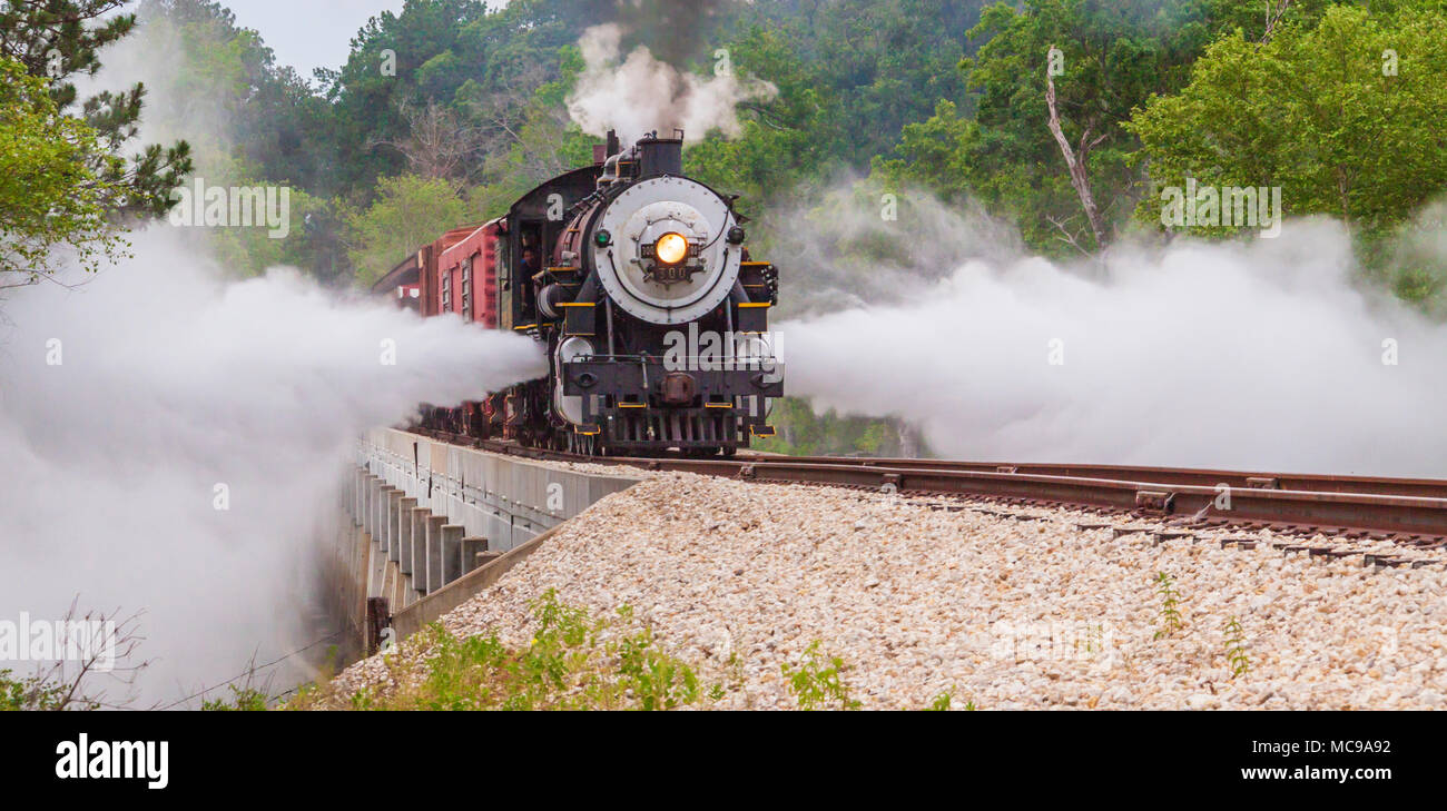 Blowdowns from 1917 Baldwin 'Pershing' steam engine locomotive 300, Consolidation classification, crossing Neches River Bridge (runbys) East Texas. Stock Photo