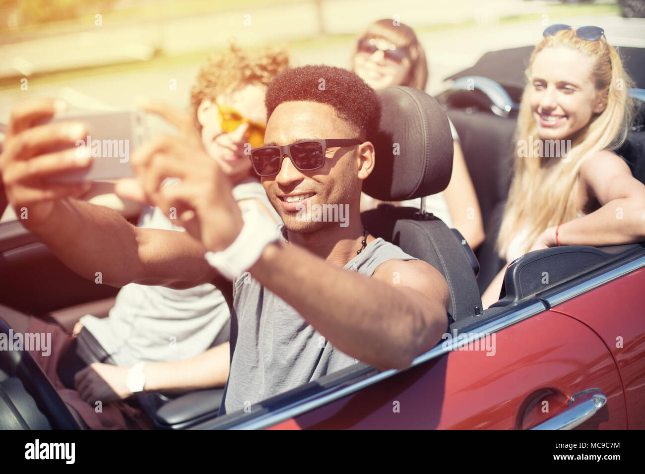 Young friends take a selfie in a cabriolet car Stock Photo
