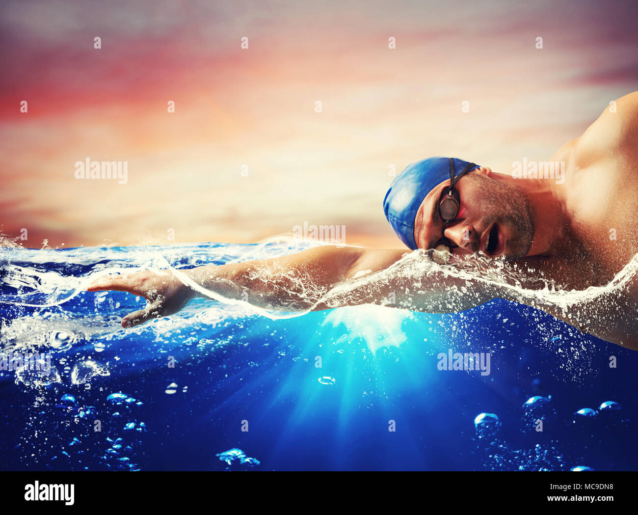 Boy swims in a blue deep water Stock Photo