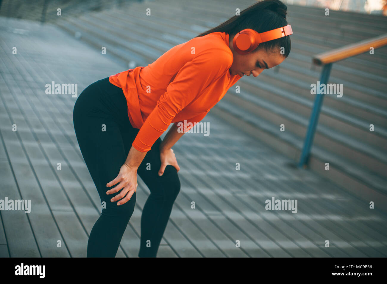Pretty young woman takes a break after running in urban area Stock ...
