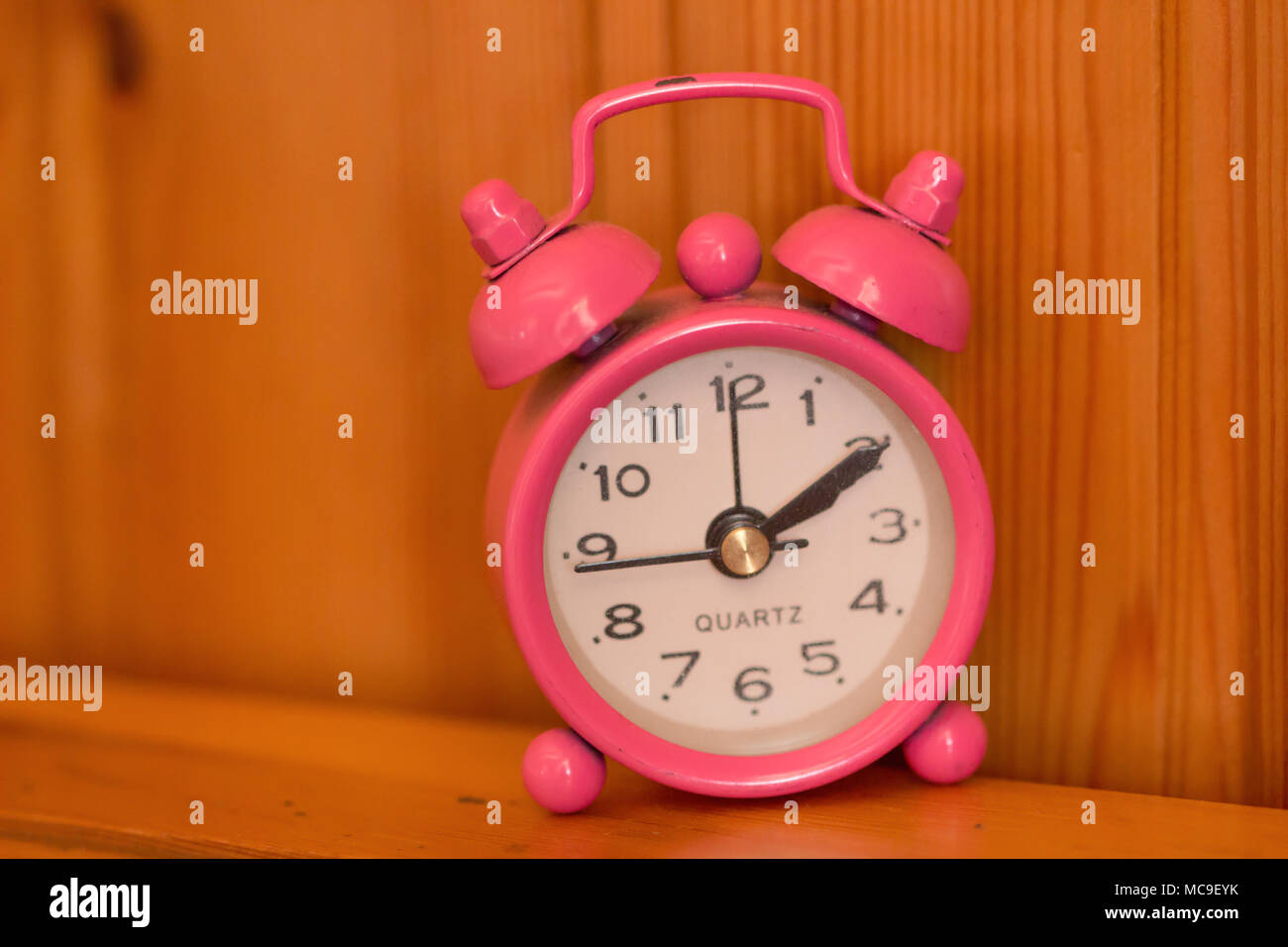 Pink Retro alarm clock on table,Vintage style filtered photo Stock
