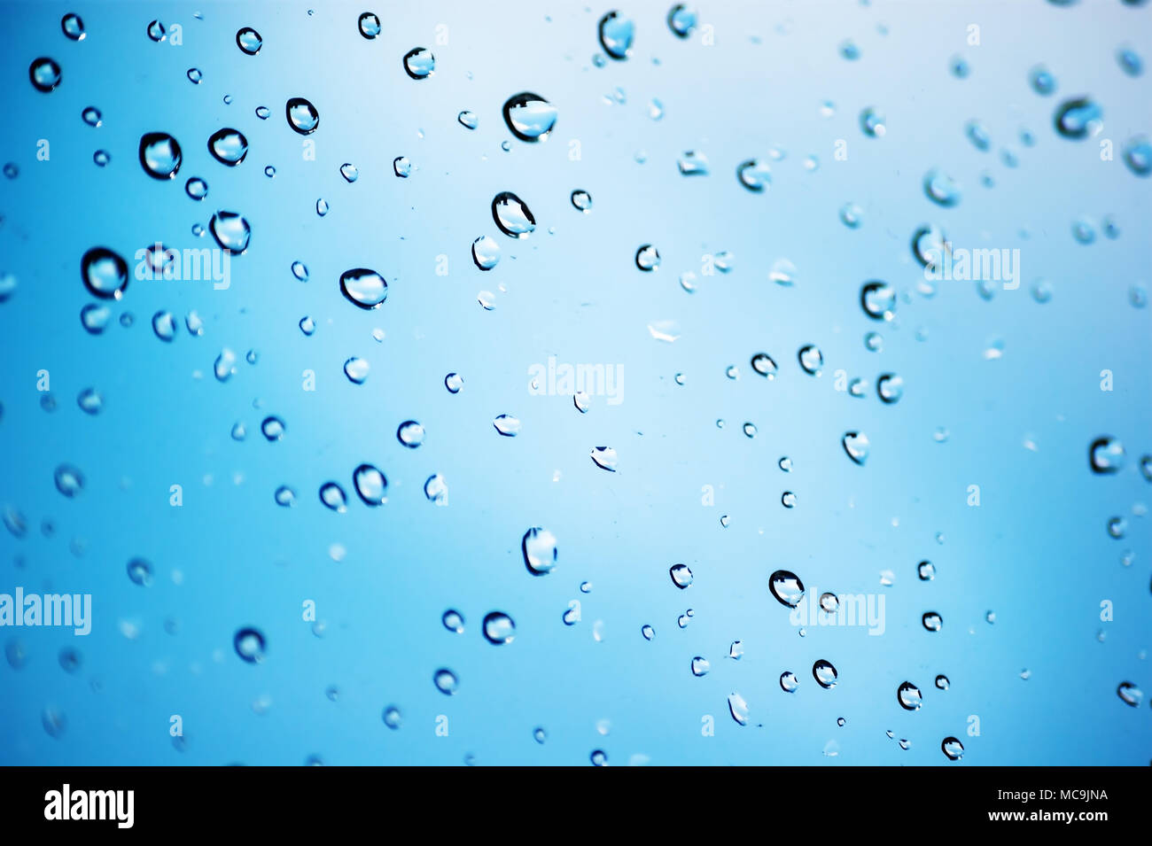 Drops of rain on glass with blue background with local focus Stock ...