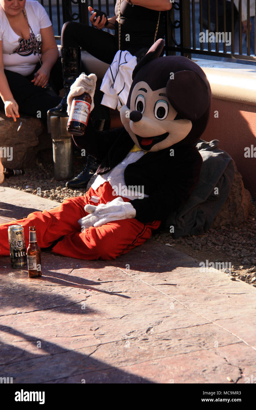 Actor playing drunken Mickey Mouse posing with beer for a picture while  sitting or almost lying on the floor: Fake or real, that's Las Vegas, NV,  USA! Stock Photo - Alamy