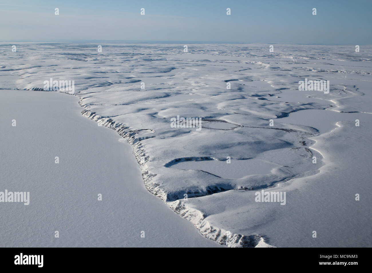 Aerial view of the frozen arctic tundra covered in snow, outside of Tuktoyaktuk, Northwest Territories, Canada. Stock Photo