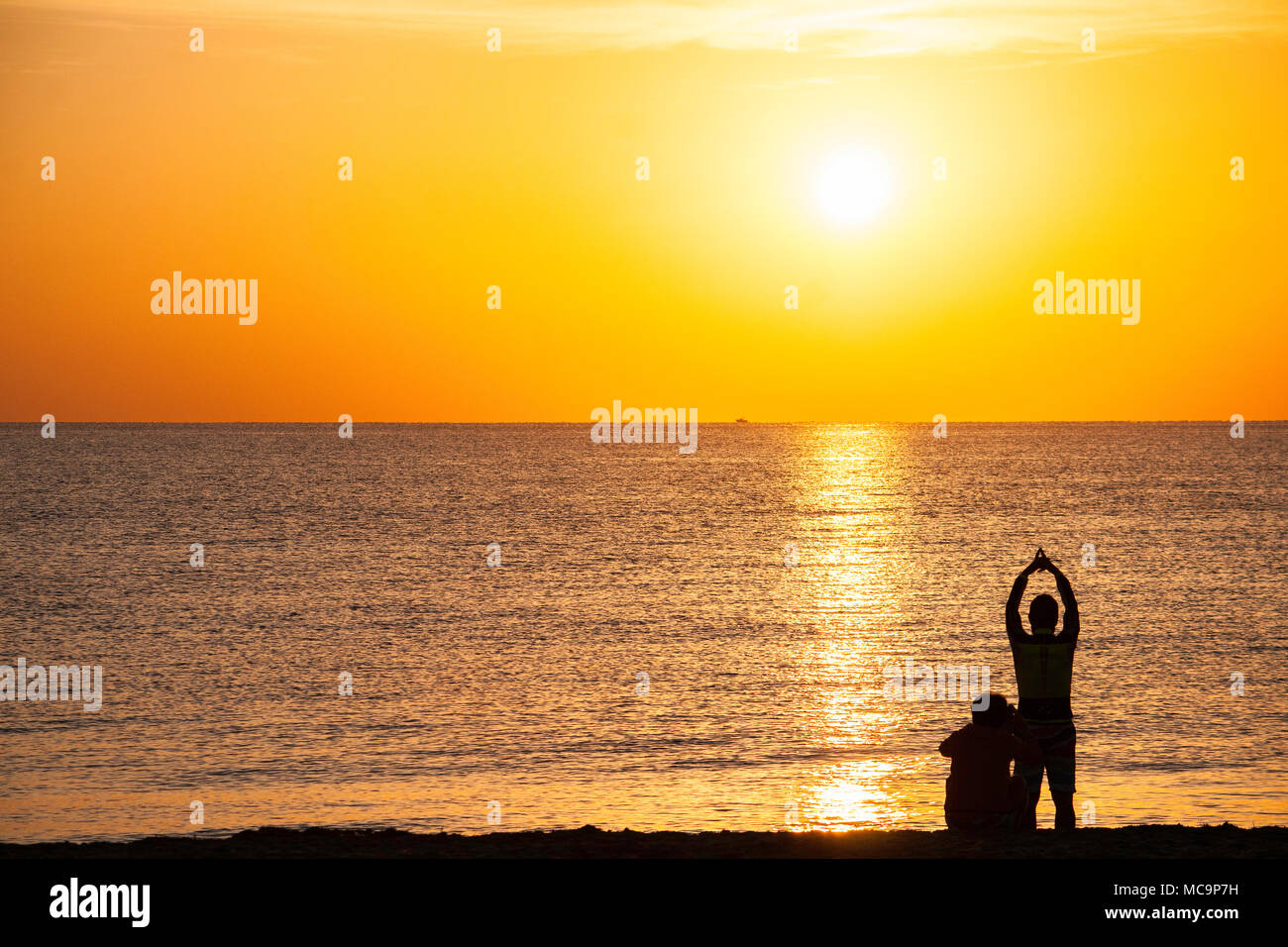 Couple on the beach posing for photos and enjoying the morning Florida sunrise Stock Photo