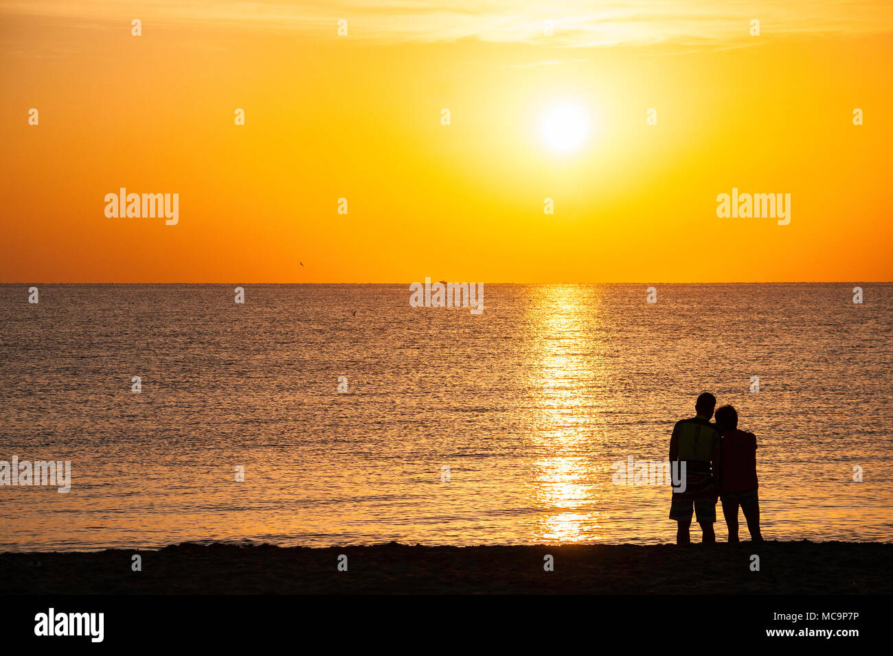 Couple on the beach posing for photos and enjoying the morning Florida sunrise Stock Photo