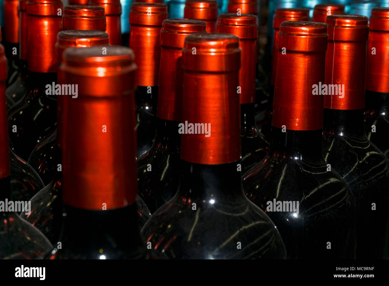 dusty necks of wine bottles with beautiful shiny bright red capsules