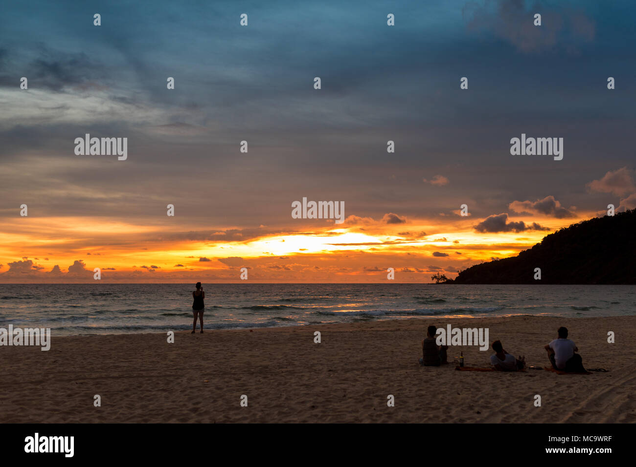 Group Of People Sitting On The Beach And Enjoying The Sunset Koh