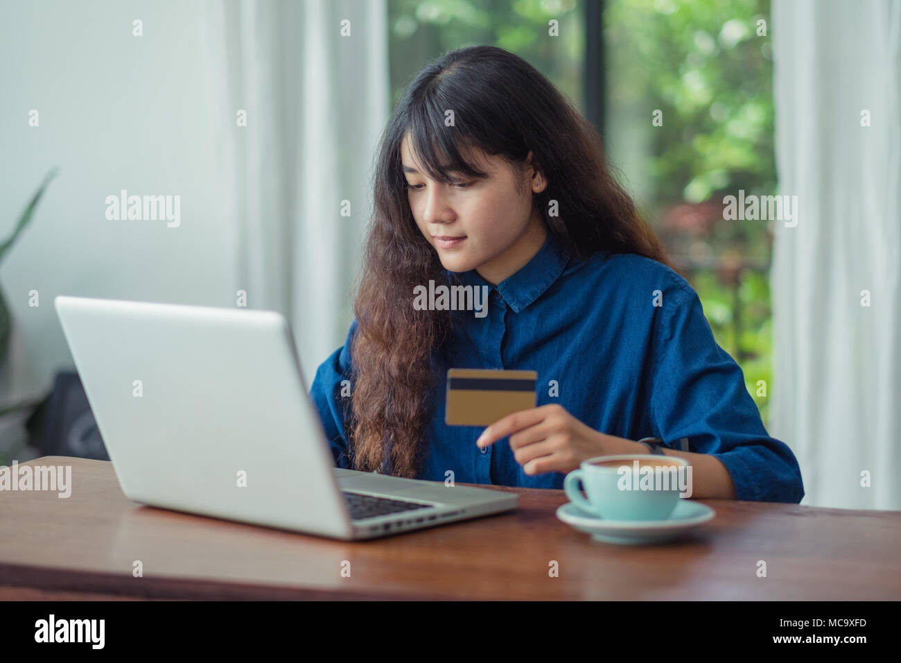 asian woman online shopping using credit card with laptop computer on wood table at cafe restaurant,Digital lifestyle concept Stock Photo