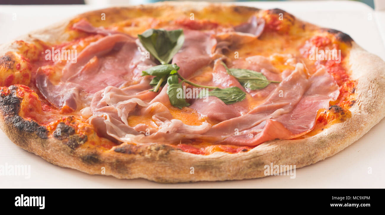 Hot true ITALIAN PIZZA pepperoni pizza on board on white wooden table with decoration. Copy space for your logo. Ideal for commercial. Stock Photo