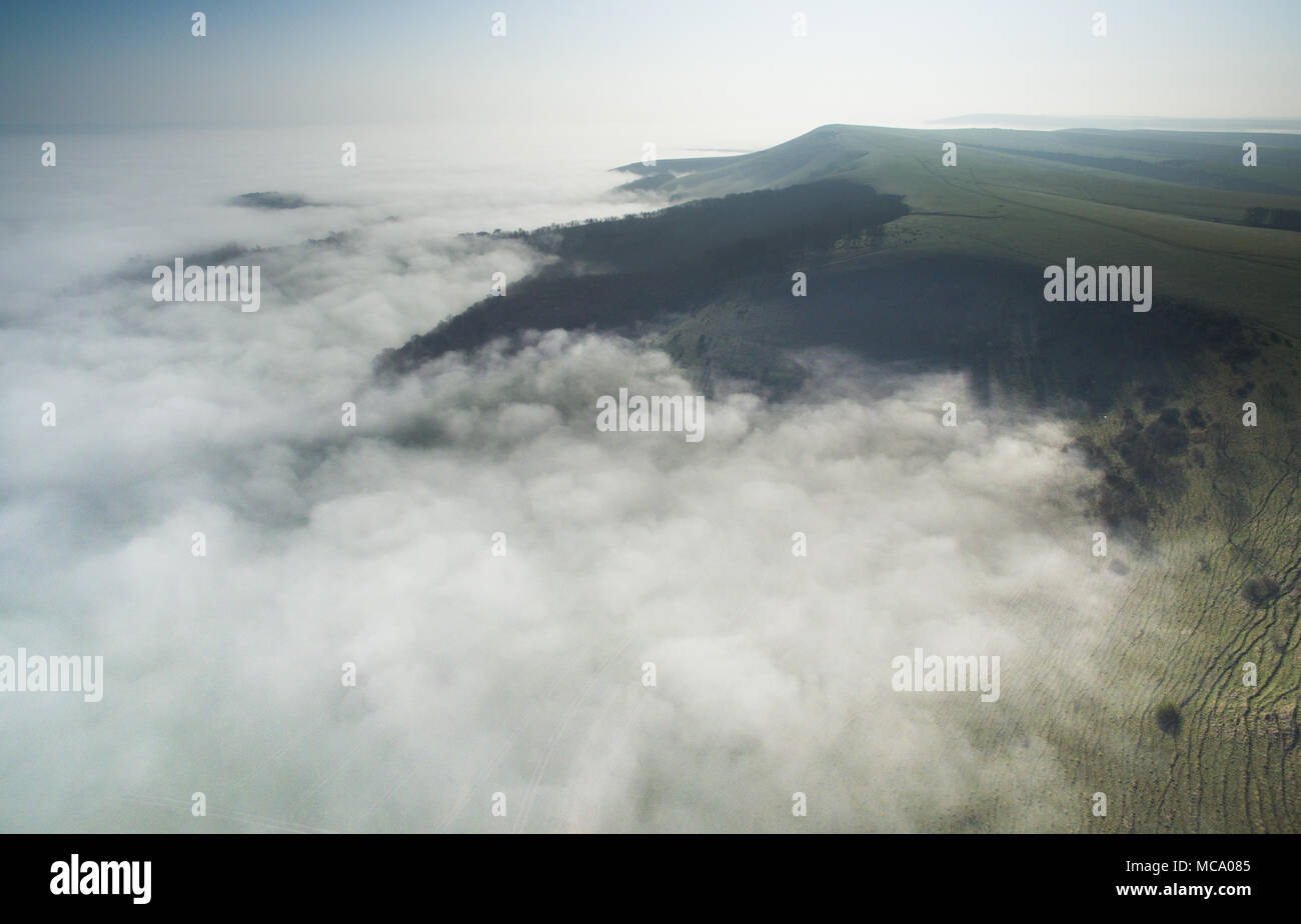 Firle, East Sussex. 14th April 2018. The South Downs emerge from low lying morning mist covering the Low Weald on a bright spring morning. © CAP/Alamy Live News Stock Photo