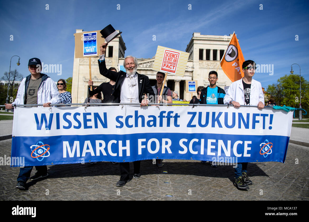 14 April 2018, Germany, Munich: Protestors start their march at the Koenigsplatz and carry a banner reading 'Wissen schafft Zukunft! March for Science' (lit. science creates future! March for Science' during the 'March for Science'. Around the world there are rallies on Saturday, where people stand up for the liberty of research and teaching. Photo: Matthias Balk/dpa Stock Photo
