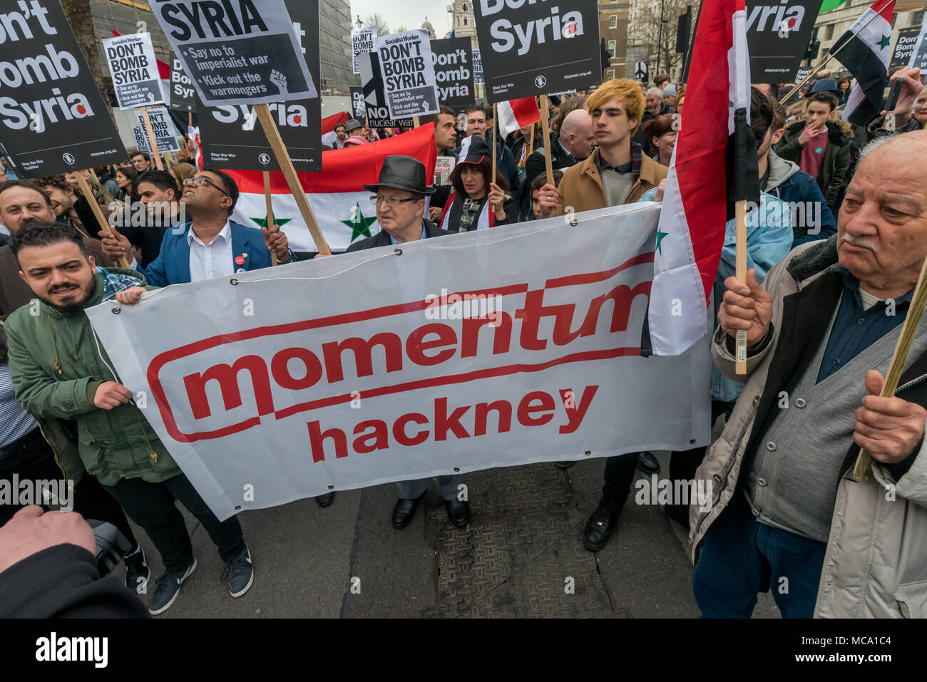 April 13, 2018 - London, UK. 13th April 2018. Hackney Momentum banner in road bloack. Stop the War and Syrians protest at Downing St calling for Theresea May to stop her plans to bomb Syria with the USA and France following the reports of a chemical weapon attack there. Stop the War handed in a letter signed by MPs, trade unionists and others and held a rally on the opposite side of Whitehall, with speeches from Stop the War and other activists. Noisy chanting continued and many of those present crossed the road to protest outside Downing St before blocking both carriageways of Whitehall. Afte Stock Photo