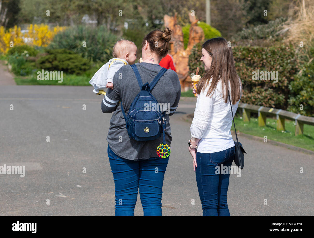 People eating ice cream in a park on a sunny and warm afternoon in the UK. Stock Photo