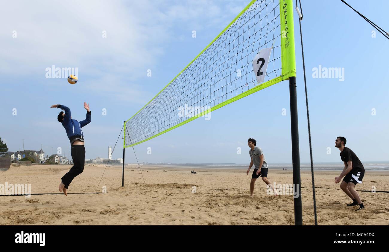 Swansea, South Wales UK, 14th April 2018 The Spring sunshine found the coastline of Wales on Saturday as warmer weather make a welcome return. Friends (from left) Sean James Davies, Matteo Colombo and Aiden Daly pictured enjoying a game of volleyball in the Spring sunshine on Swansea Bay. Robert Melen/Alamy Live News. Stock Photo