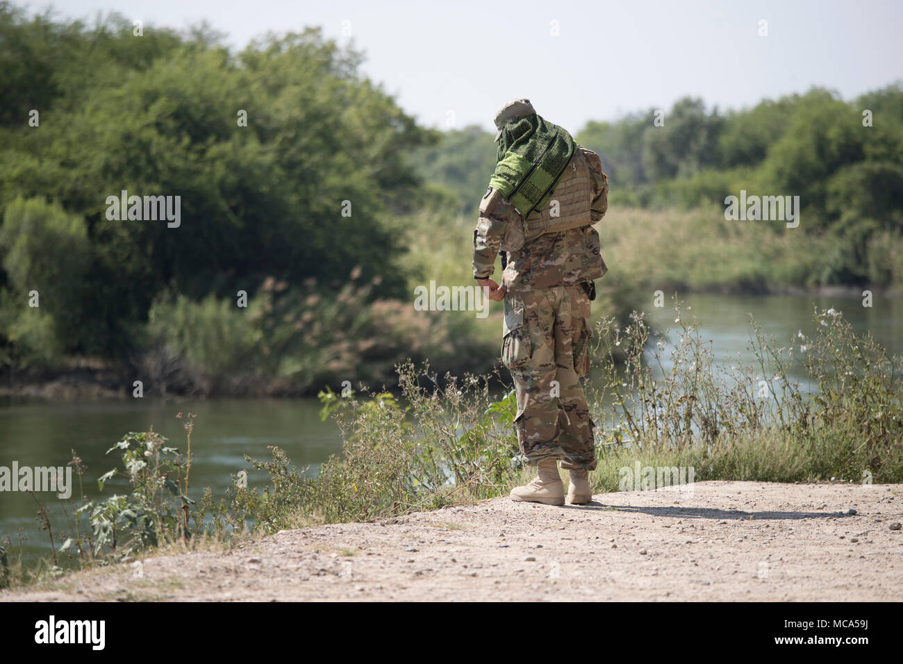 Texas National Guard troops man an observation post on the Texas side of the Rio Grande River as it flows between the bluffs of Roma and the Mexican city of Ciudad Miguel Aleman to the left. Stock Photo
