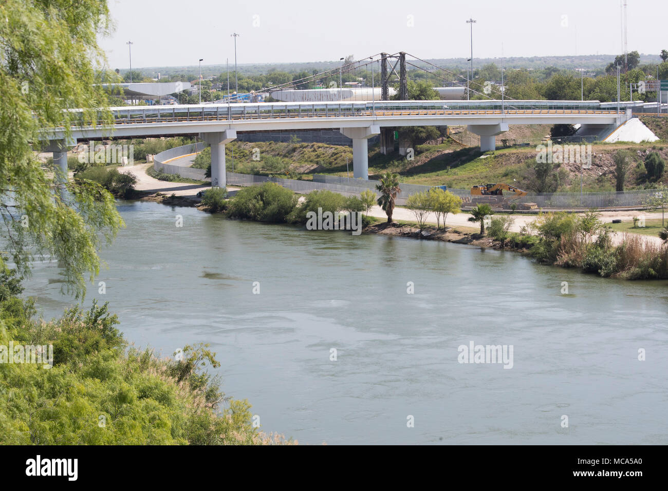 The Rio Grande River flows southward between the bluffs of Roma, TX., and the Mexican city of Ciudad Miguel Aleman to the right. Stock Photo
