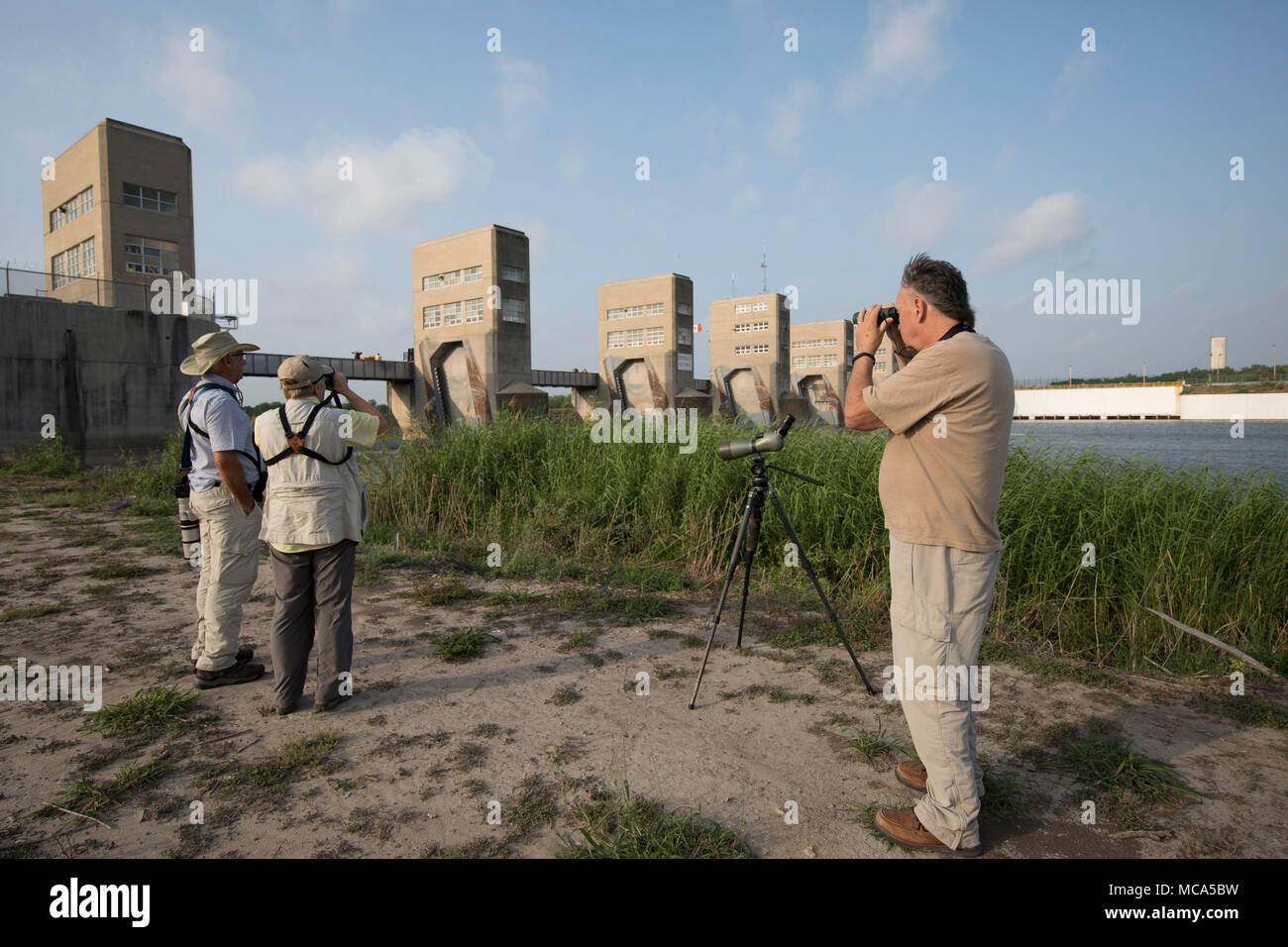 Bird watchers scan the horizon into Mexico at the Anzalduas Dam in Hidalgo County, TX, on the Rio Grande River. The area would be isolated by President Donald Trump's proposed border wall. Stock Photo
