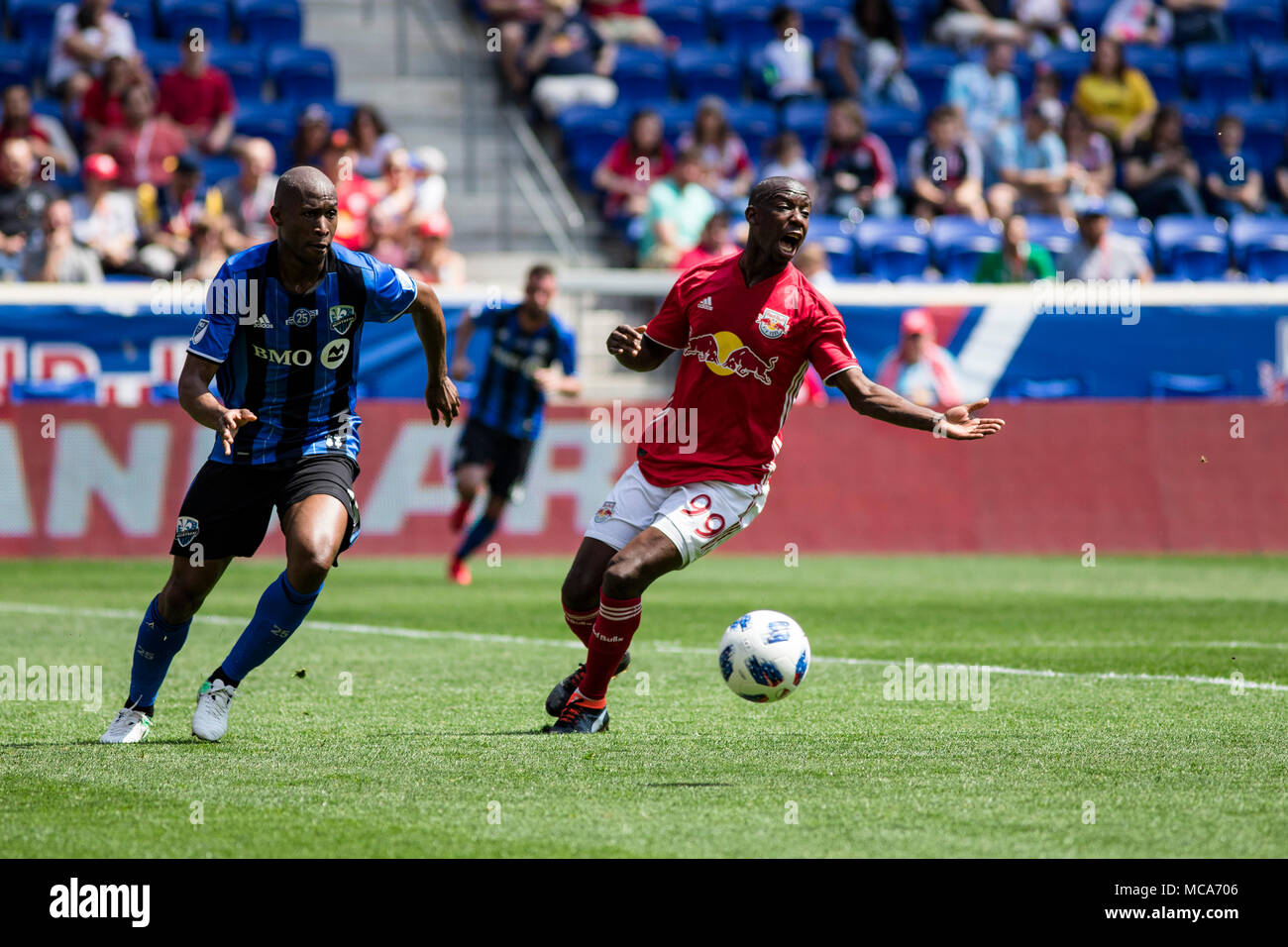 New Jersey, USA. 14th April, 2018. Bradley Wright-Phillips (99) and Rod Fanni (15) battle for the ball in the first half of the match. The Red Bulls defeated the Impact 3-1. Stock Photo