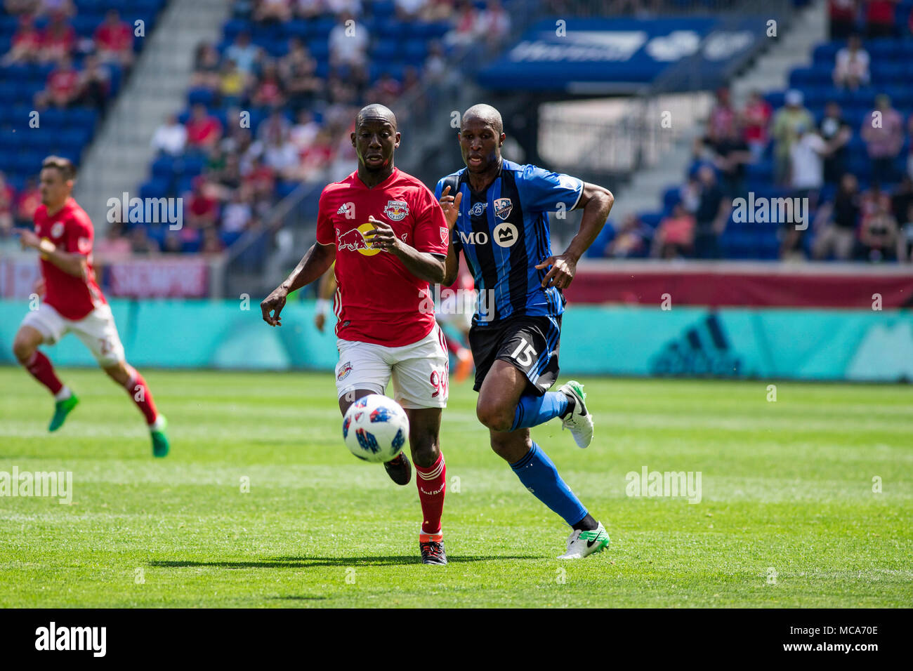 New Jersey, USA. 14th April, 2018. Harrison, NJ; Bradley Wright-Phillips (99) and Rod Fanni (15) battle for the ball in the first half of the match. The Red Bulls defeated the Impact 3-1. Stock Photo