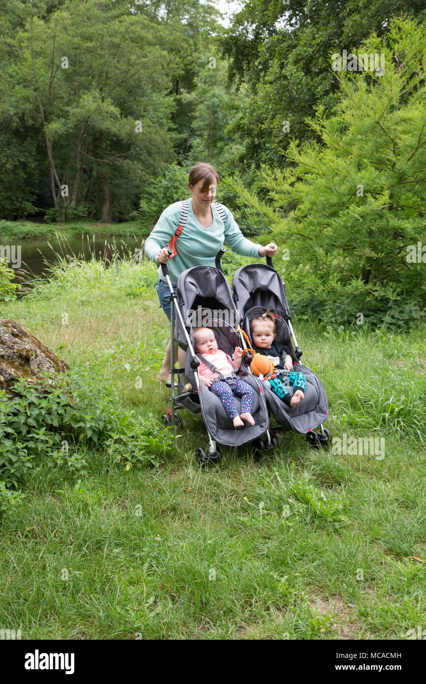 Young mum pushing a double buggy on holiday with twins Stock Photo Alamy