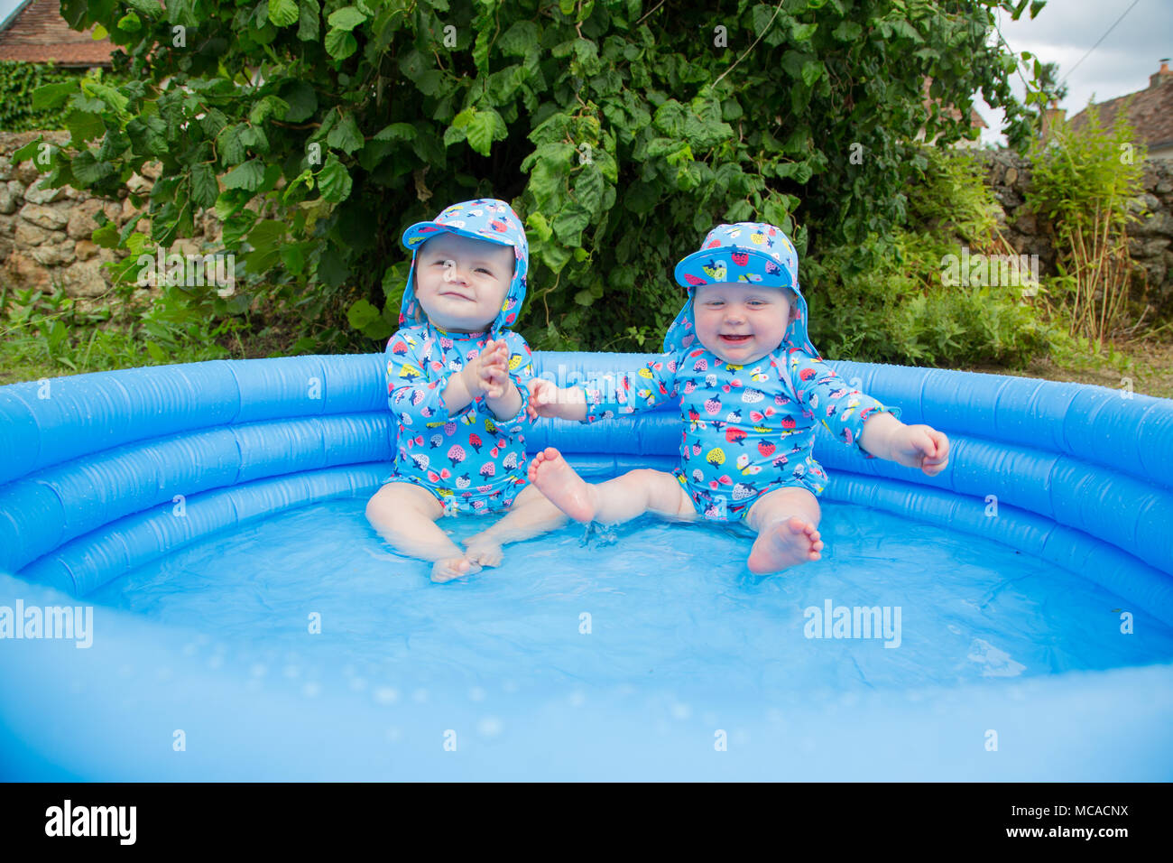 Babies plating in a paddling pool Stock Photo Alamy