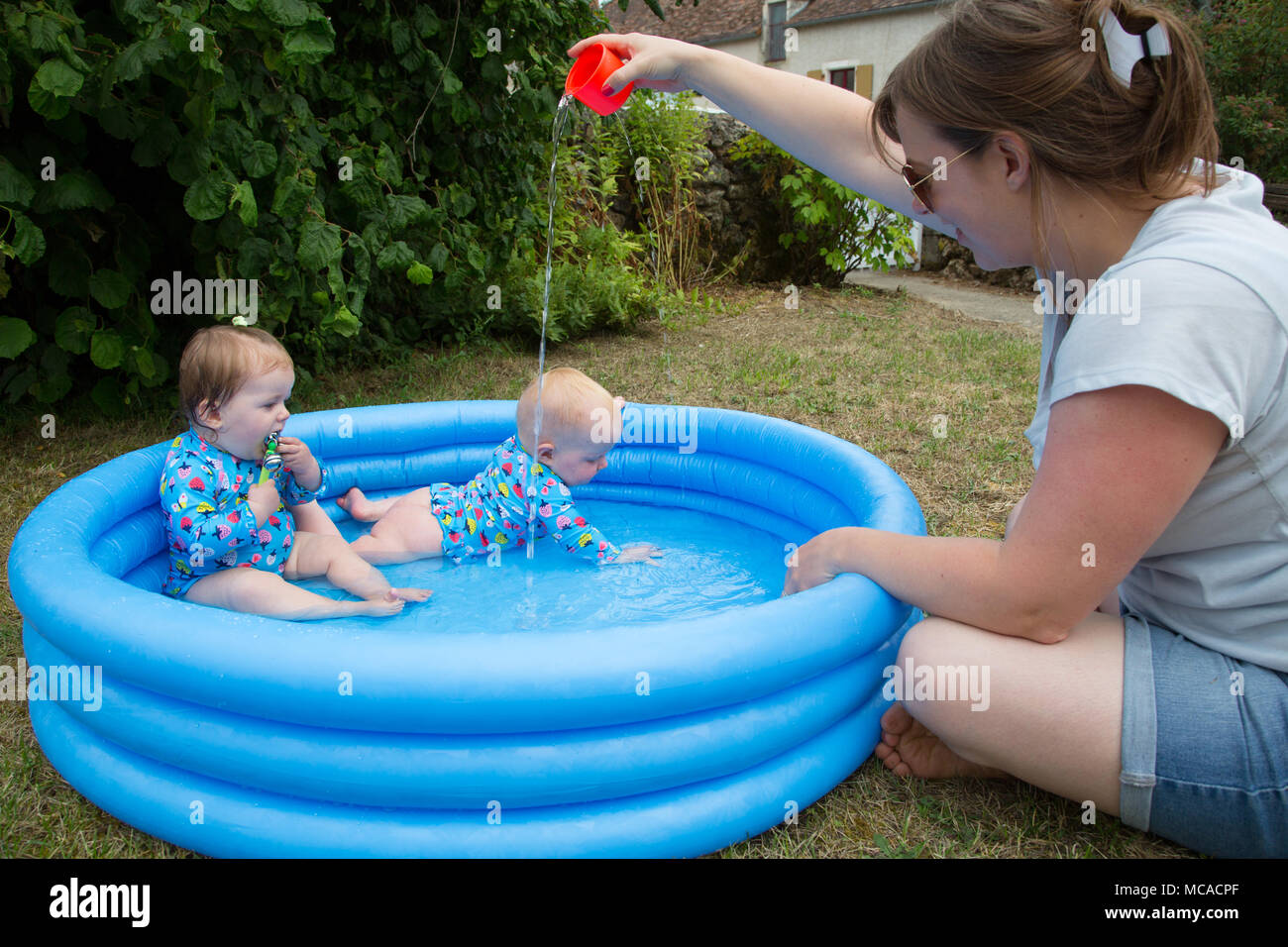 Babies plating in a paddling pool Stock Photo Alamy