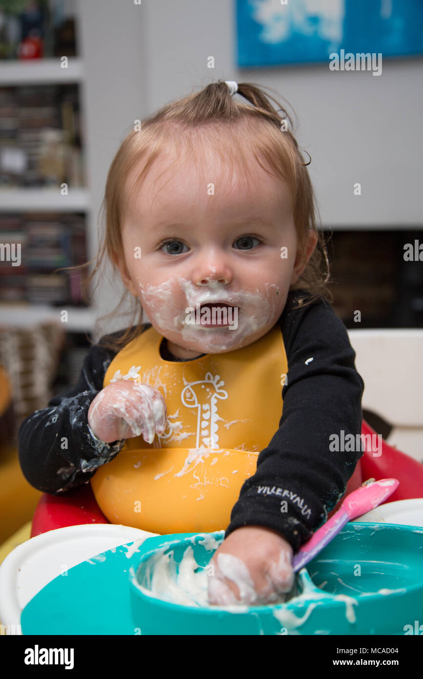 9 month old baby eating yoghurt baby led weaning Stock Photo Alamy