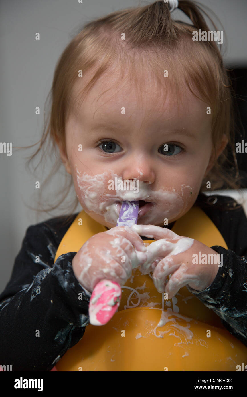 9 month old baby eating yoghurt baby led weaning Stock Photo Alamy