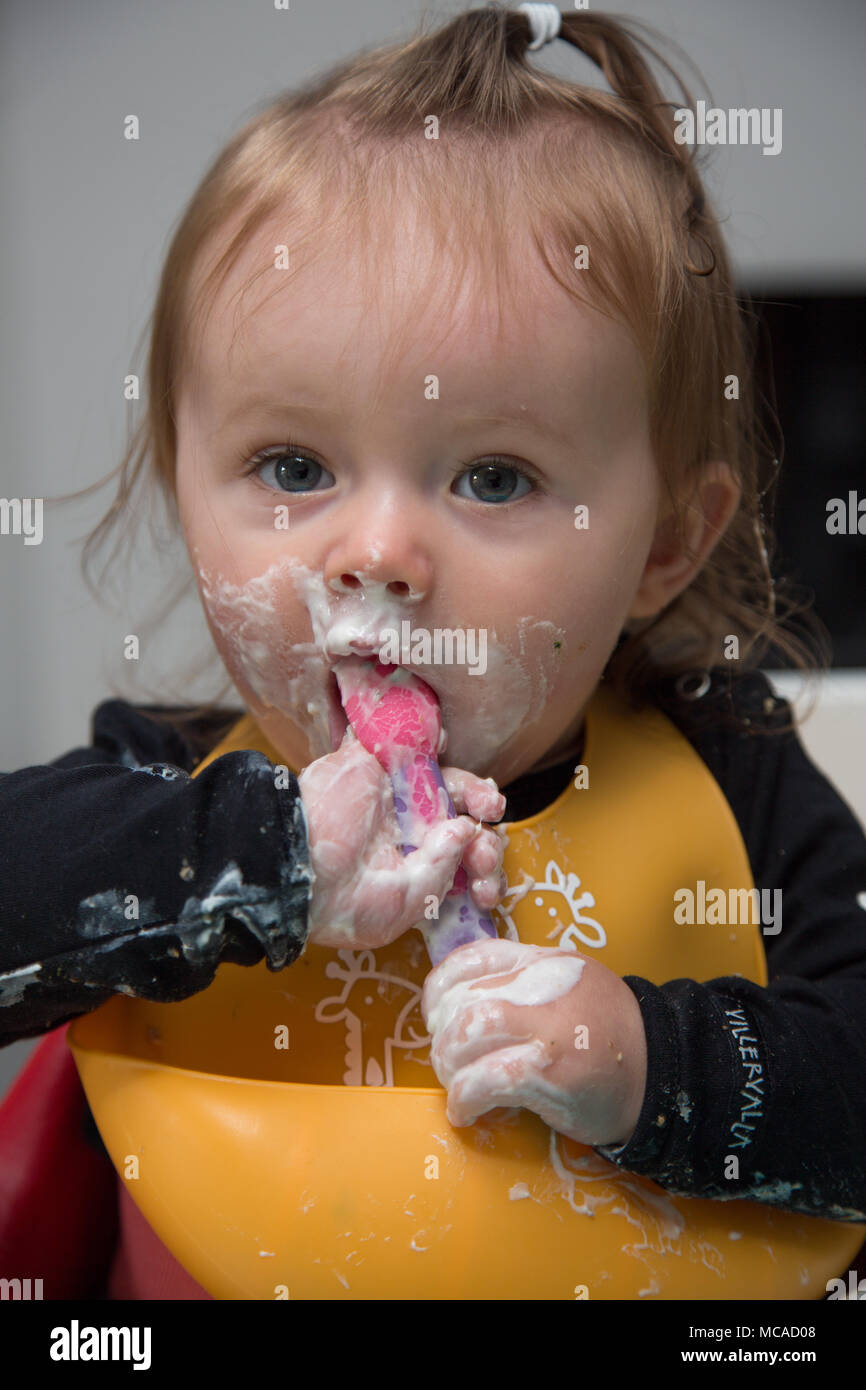 9 month old baby eating yoghurt baby led weaning Stock Photo Alamy