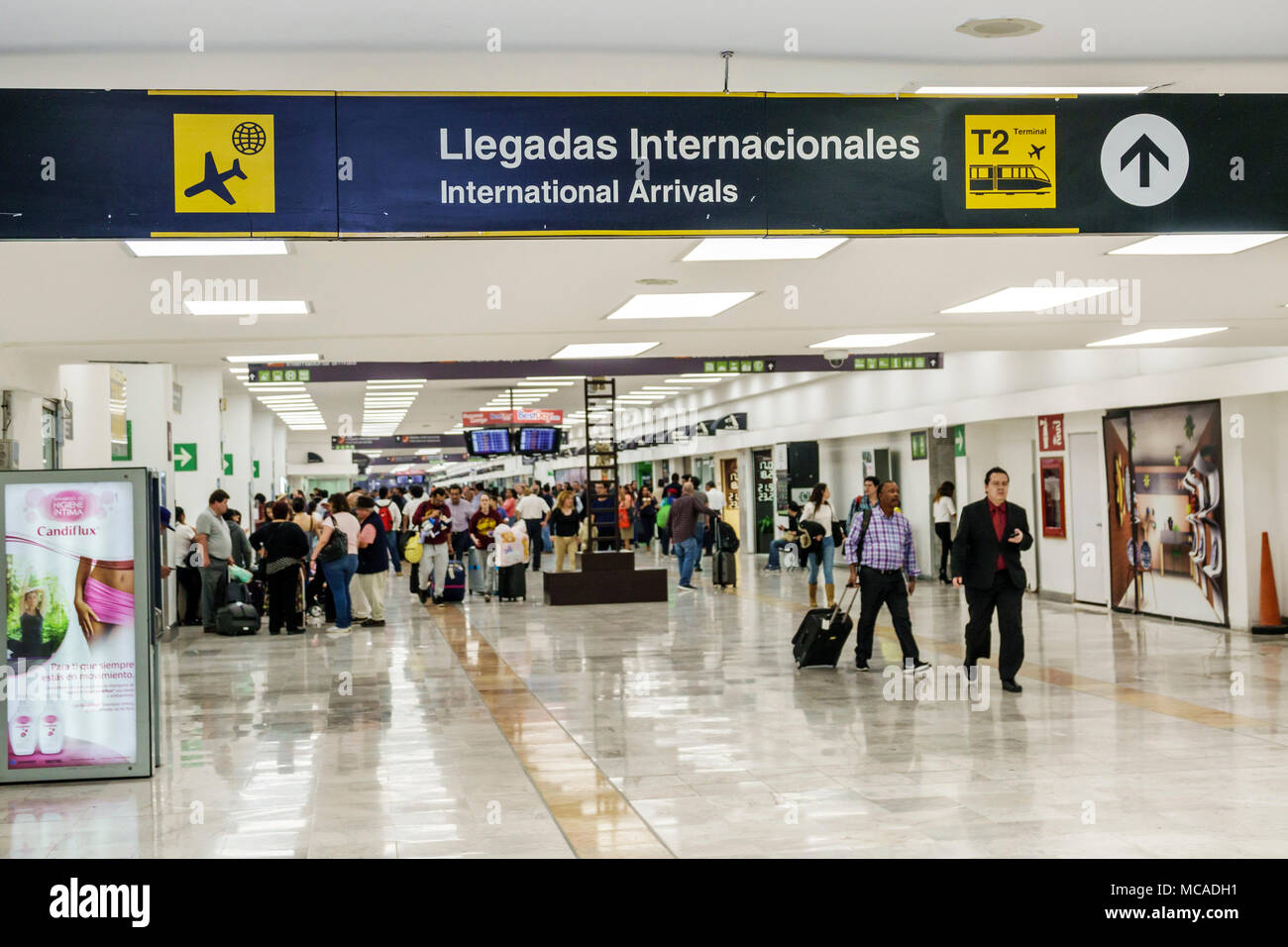 Mexico City,Mexican,Hispanic,Benito Juarez International Airport MEX,terminal,international arrivals,bilingual sign,passenger passengers rider riders Stock Photo