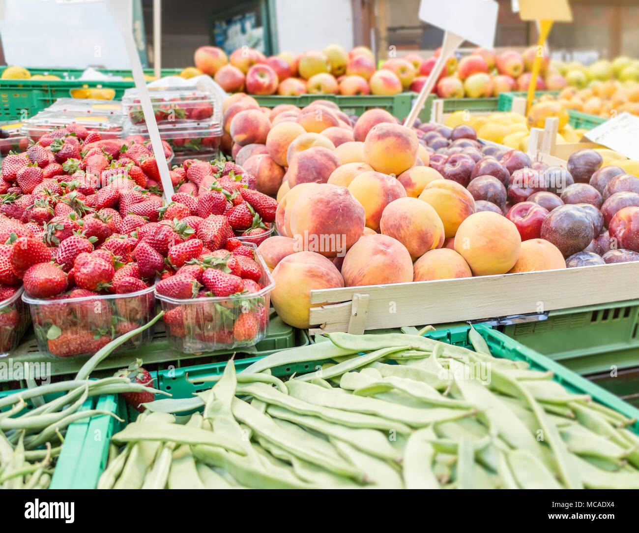 Strawberries, Peaches, plums, apples on market stand, natural daylight, farmers market Stock Photo