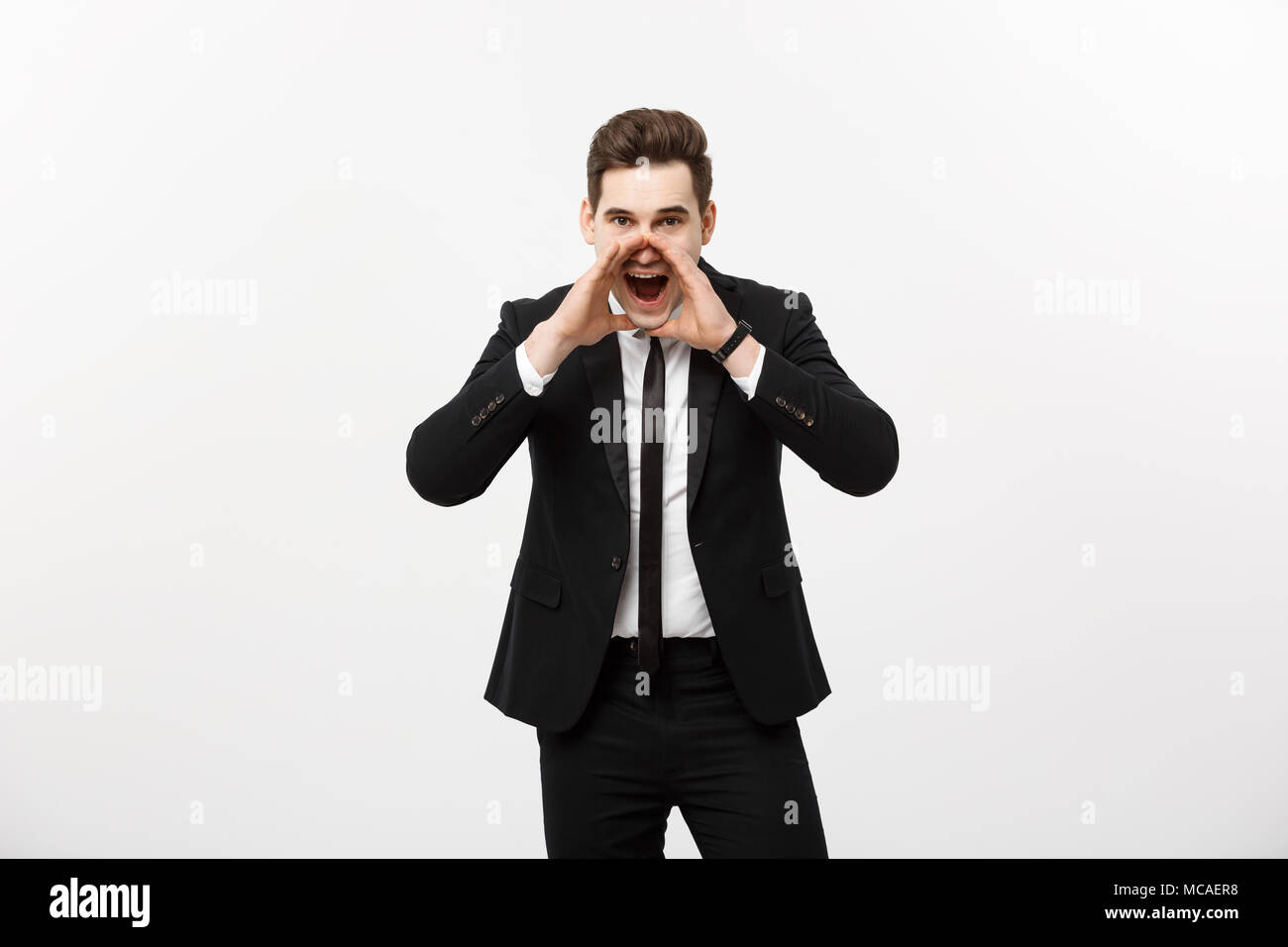 Business Concept: young handsome business man shouting and isolated on white. Stock Photo