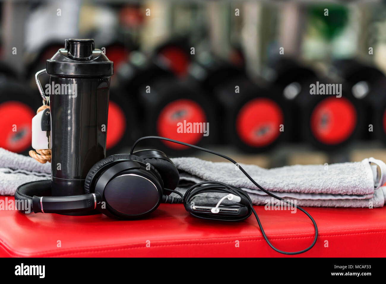 Plastic shaker, towel and MP3 player in gym Stock Photo - Alamy