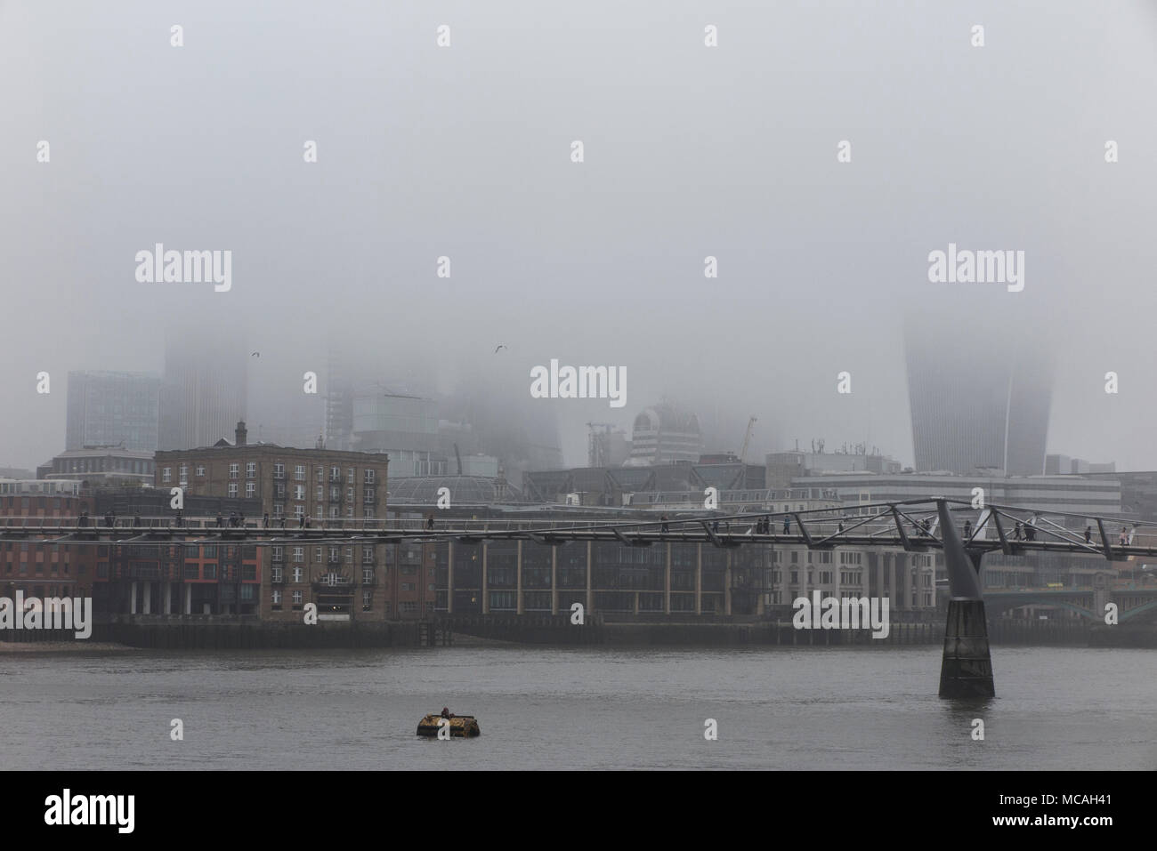 a gloomy, misty day in London with the skyscrapers shrouded in mist and