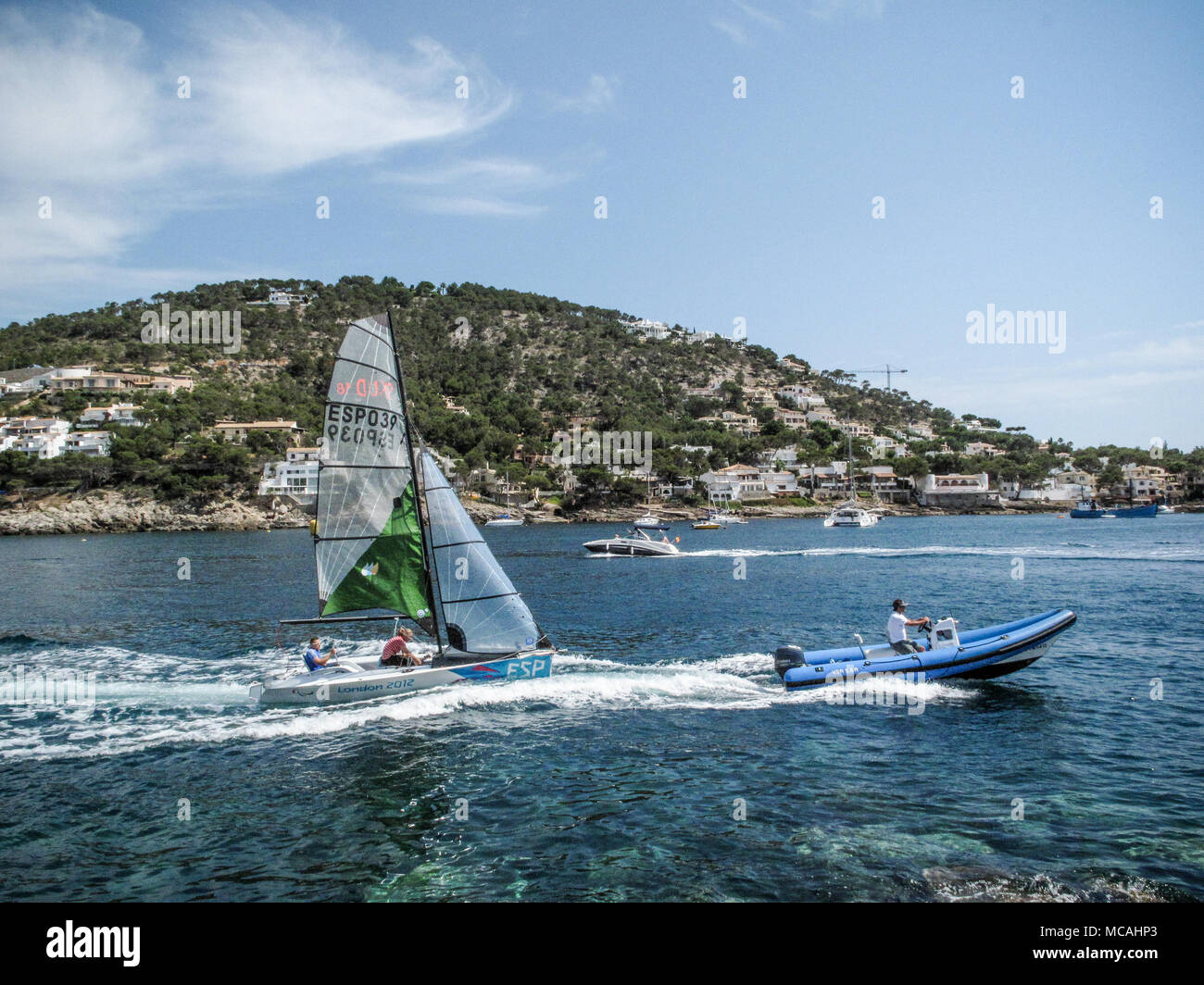A RIB or rigid inflatable boat passes a sailing dinghy in Puerto