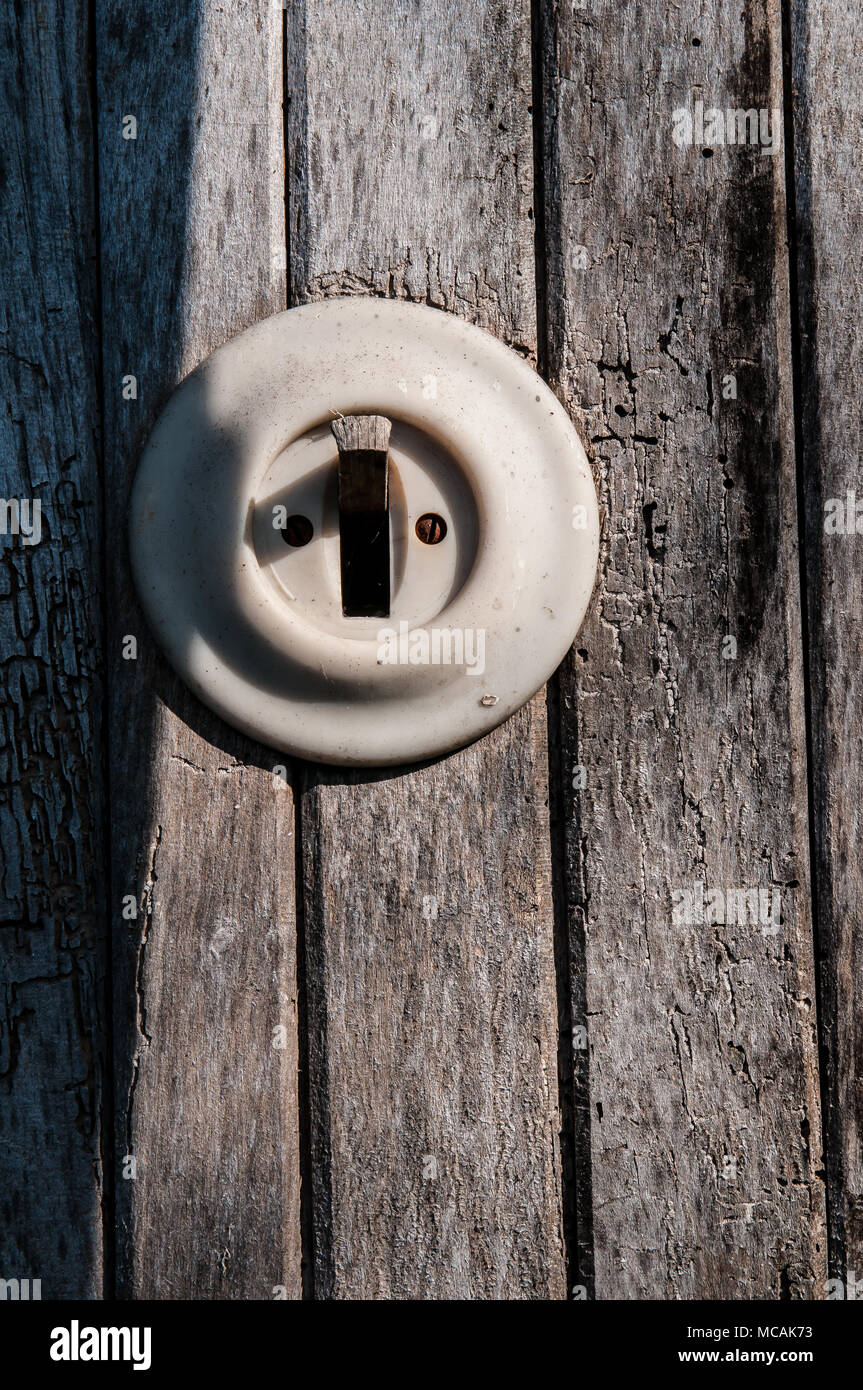 old electric light switch on a wooden wall Stock Photo