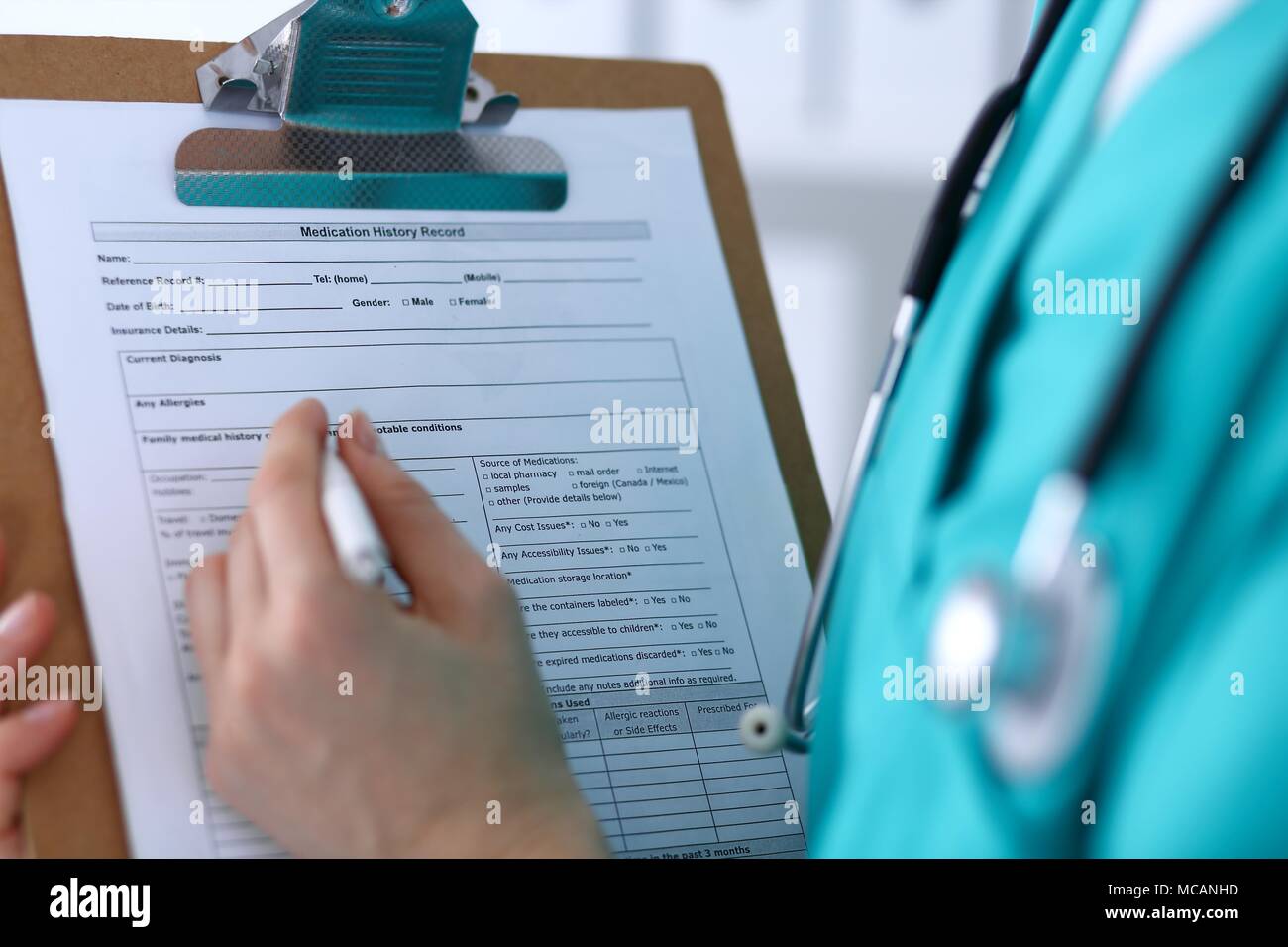 Female doctor filling up medical form on clipboard closeup. Physician ...