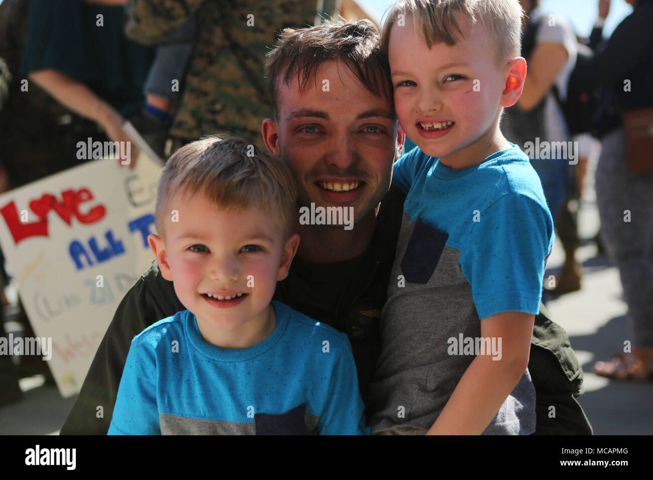 Sons reunite with their father following the 15th Marine Expeditionary Unit’s aviation combat element’s return to Marine Corps Air Station Miramar, Calif., Feb. 1. During the deployment, more than 4,500 Marines and Sailors of the America Amphibious Readiness Group and embarked 15th MEU conducted maritime security operations and multiple military-to-military exchanges with partner nations in support of regional security, stability and the free flow of maritime commerce in the Indo-Asia-Pacific and Middle East regions. (U.S. Marine Corps photo by Sgt. David Bickel/Released) Stock Photo