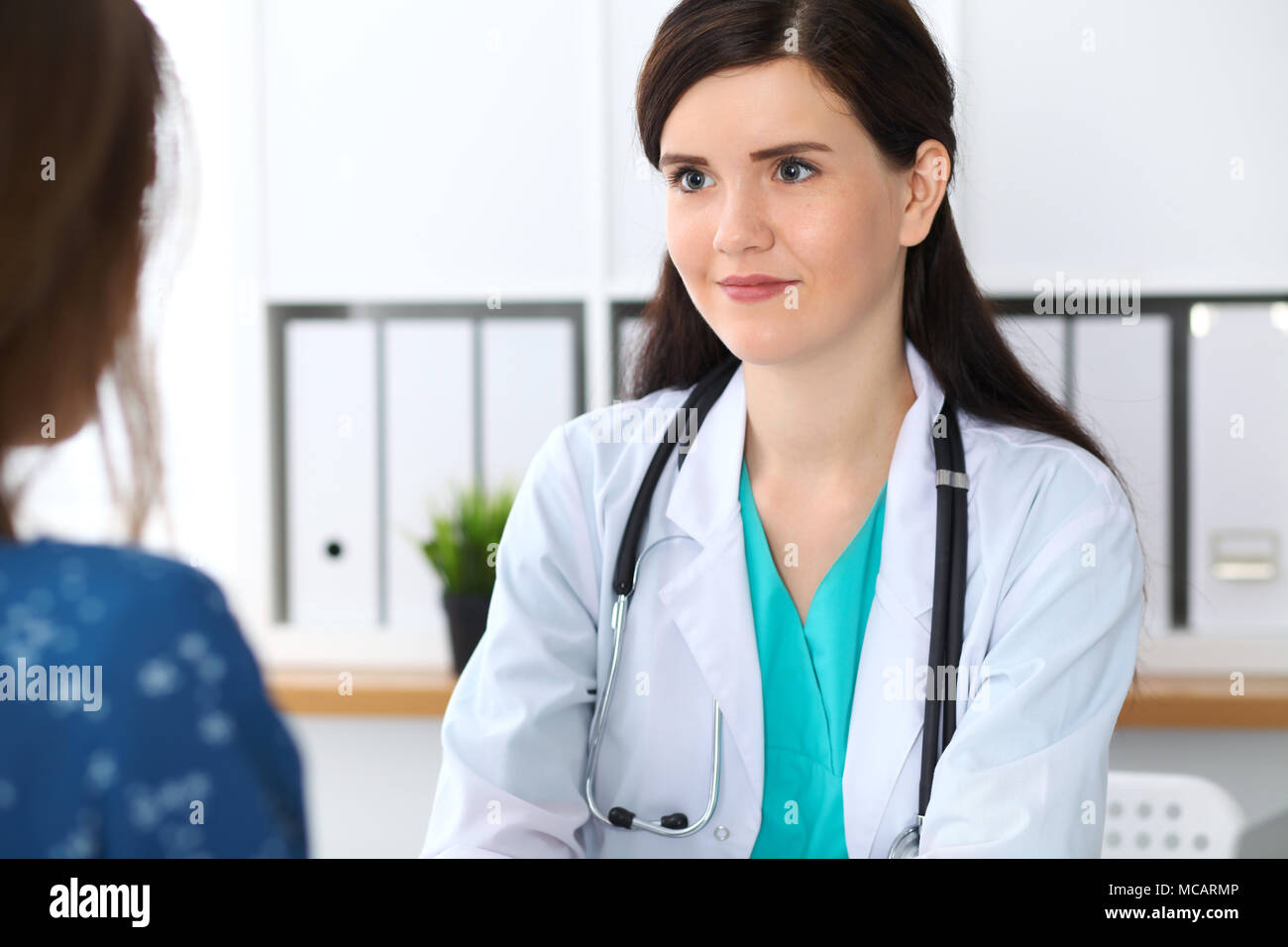 Beautiful Female Doctor Reassuring Her Patient While Sitting At The