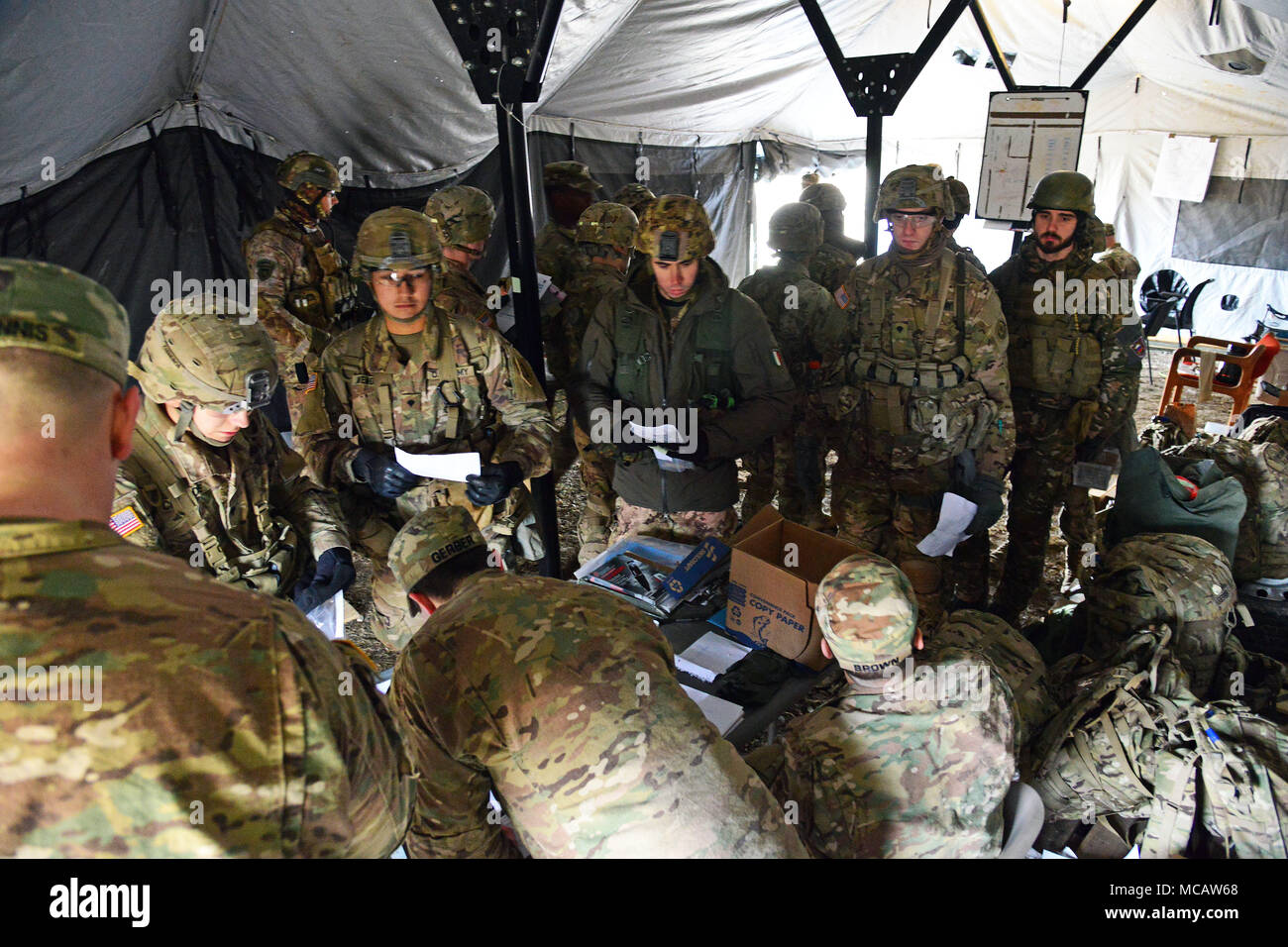 U.S. Army Paratroopers assigned to the 1st Battalion, 503rd Infantry Regiment, 173rd Airborne Brigade, Italian Army Paratroopers from Brigata Julia Paracadutisti Alpini and the Brigata Folgore, prepare for a land navigation event during the weeklong testing for the Expert Infantryman Badge. The soldiers must complete a number of prerequisites and pass a battery of graded tests on basic Infantry skills Feb. 6, 2018 at Cellina Meduna area, Pordenone, Italy. (U.S. Army Photo by Paolo Bovo) Stock Photo