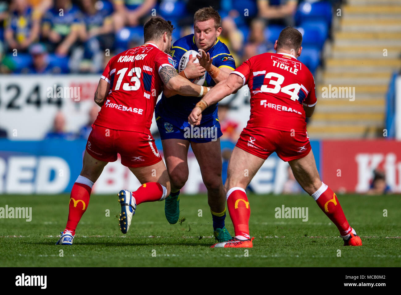 Warrington Wolves's Mike Cooper is tackled by Hull's Ben Kavanagh (L) and Danny Tickle (R)  14th April 2018 , The Halliwell Jones Stadium Mike Gregory Way, Warrington, WA2 7NE, England;  Betfred Super League rugby, Round 11, Warrington Wolves v Hull Kingston Rovers Stock Photo