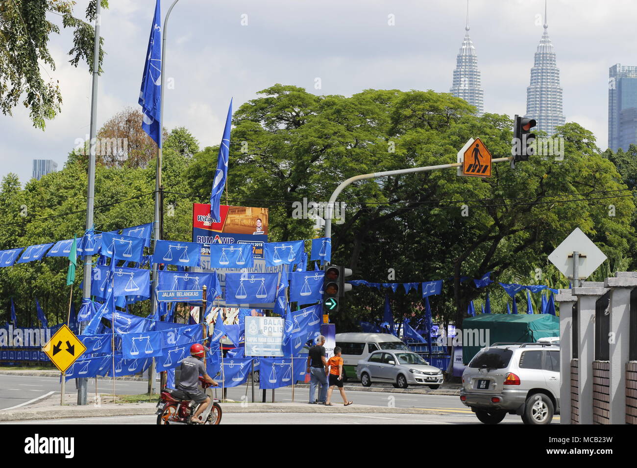Kuala Lumpur, Malaysia. 15th April, 2018. The upcoming May 2018 general elections is expected to be a keenly contested fight between the ruling coalition party and the opposition alliance. Which way will it go? Blue flags seen here belong to the ruling party Barisan Nasional. The iconic Petronas Twin Towers is photographed in the background. Credit: Beaconstox/Alamy Live News. Stock Photo