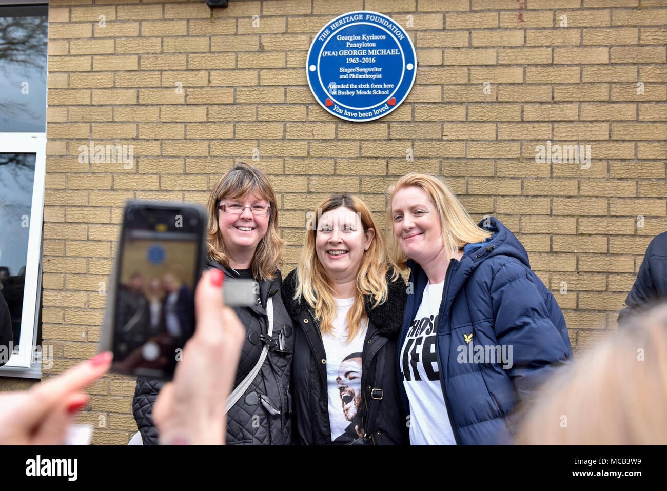 Bushey, UK.  15 April 2018. (L to R) Jane Cronk, Toni Parkins and Jayne Apps, fans from Bushey, are photographed in front of a blue plaque commemorating the life of singer George Michael which has been unveiled at Bushey Meads school in Bushey, north west London.  George Michael was a student at the school for two years prior to finding success with Andrew Ridgeley in the group Wham! before moving on to a successful solo career.   The blue plaque was made possible by the George Michael Appreciation Society and the Heritage Foundation. Credit: Stephen Chung / Alamy Live News Stock Photo