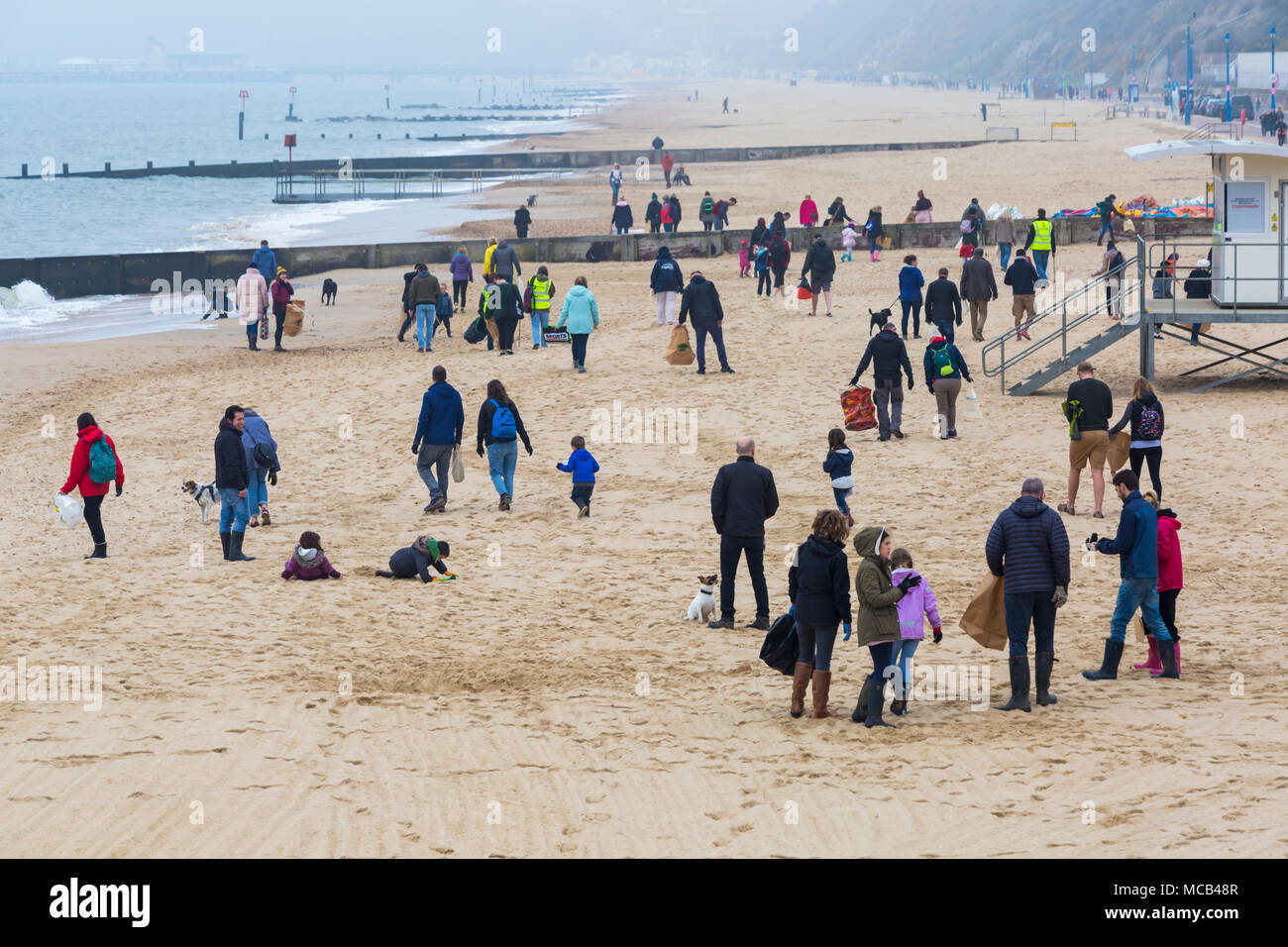 Kids picking rubbish on the beach hires stock photography and images