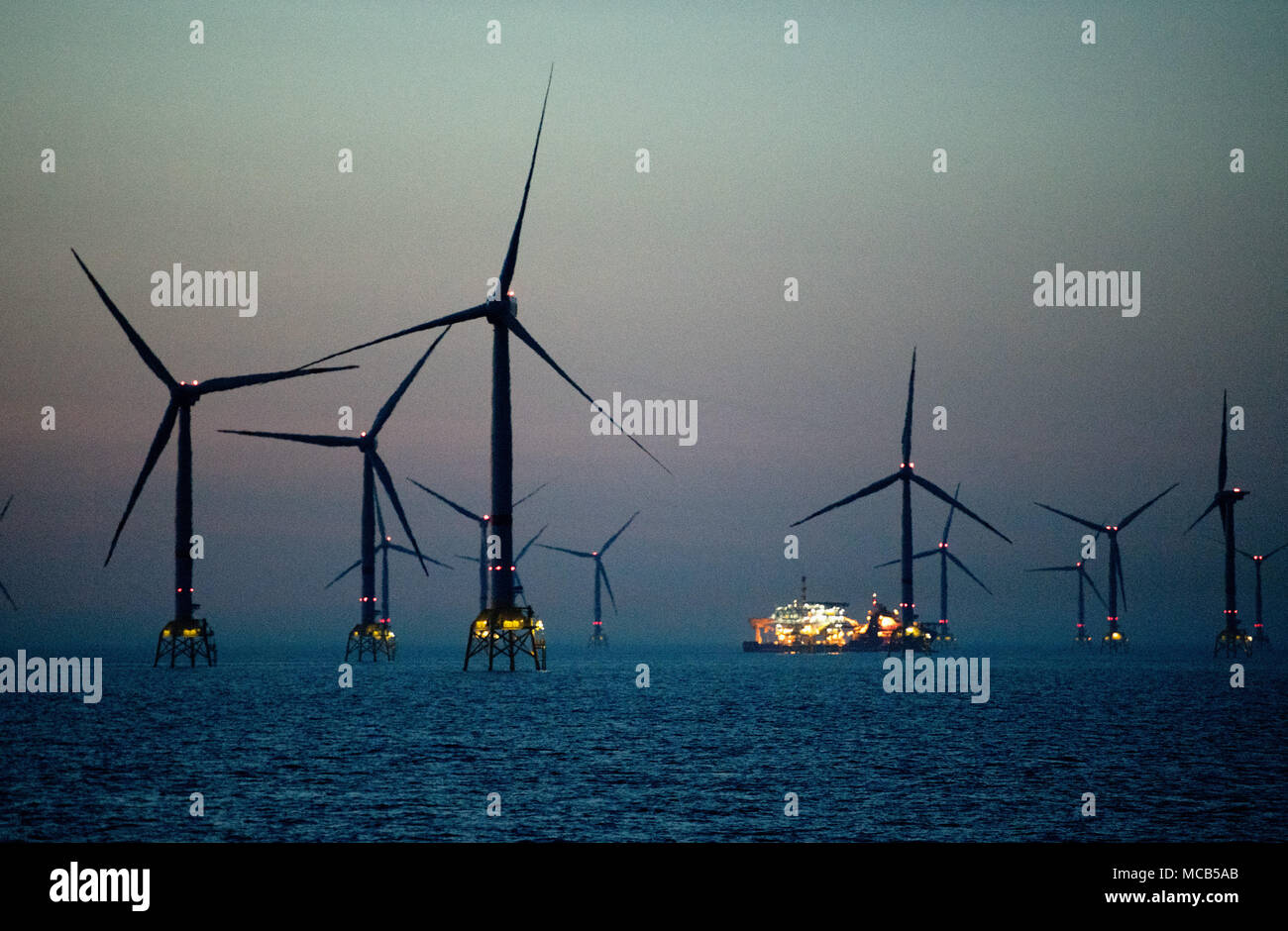 08 April 2018, Germany, Sassnitz: Offshore wind mills at the Baltic Sea wind park 'Wikinger' (lit. Vikings) of energy supplier Iberdrola at the Baltic Sea in front of the island of Ruegen. The 1.4 million euros expensive wind park 'Wikinger', which is 35 kilometres away from Ruegen, is able to produce power for 350.000 households with the 70 wind turbines of the five megawatts class 35. The transmission system operator 50 Hertz is responsible for the grid connection and the laying of the power cable Ostwind 1 (lit. East wind 1). The cable runs from the wind park 30 kilometres across the Baltic Stock Photo